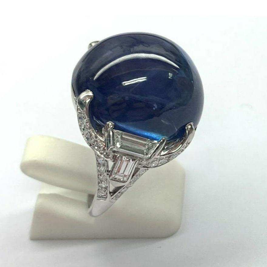 Art Deco platinum intricately handcrafted mounting set with a large round cabochon-cut, natural blue sapphire weighing approximately 41.60 carats.  Sapphire measurements 19.42 x 17.64 x 13.39mm.  The beautiful translucent blue color is the highlight