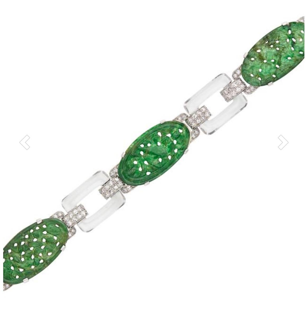 Art Deco Platinum, Carved Jade, Rock Crystal and Diamond Bracelet composed of 4 oval carved Natural Jadeite Jade measuring approximately 13.5 x 25.0 mm., quartered by diamond-set brackets, spaced by 4 rock crystal buckle links joined by diamond-set