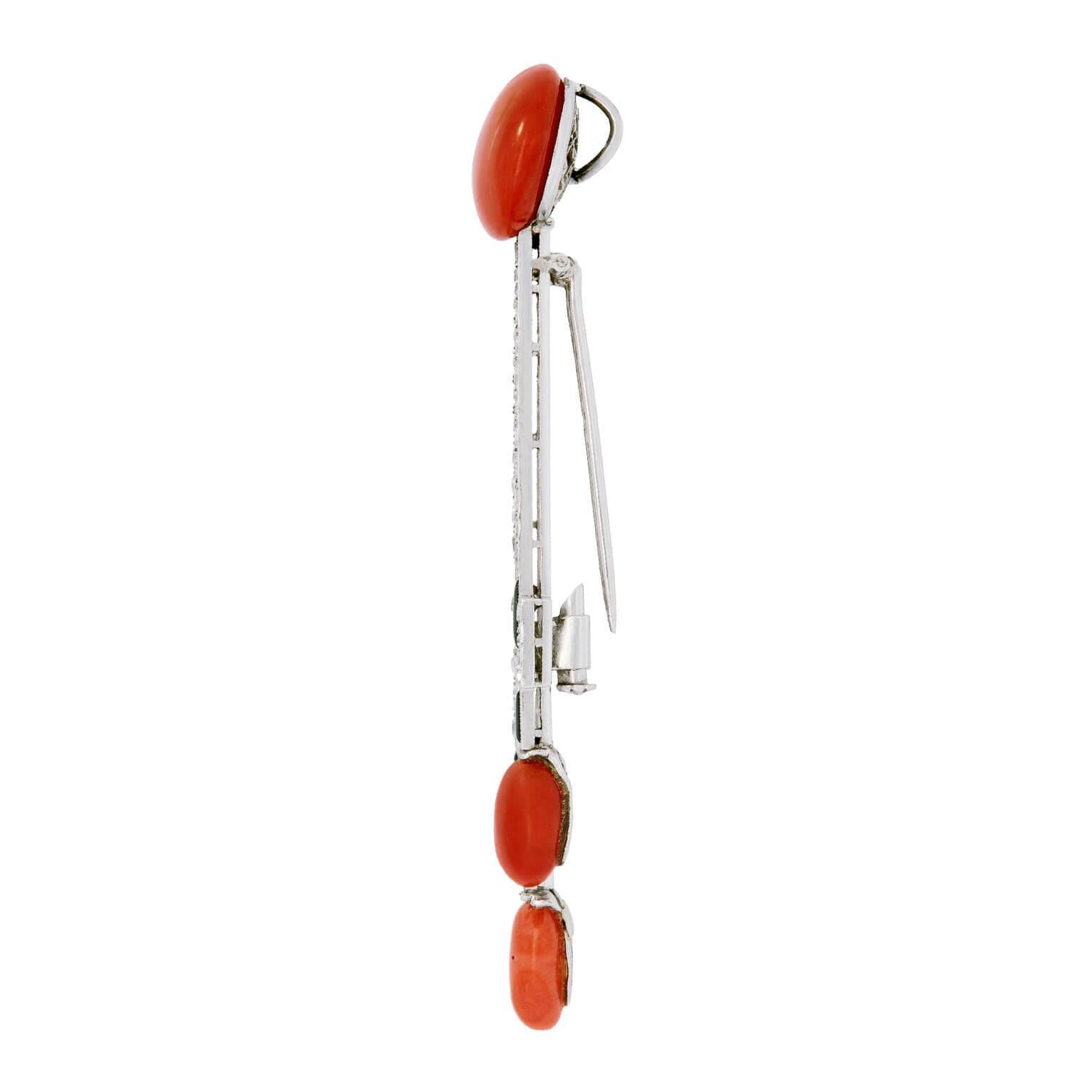 Una favolosa spilla/pendente dell'epoca Art Deco (ca. 1920)! Realizzato in platino, questo pezzo inizia con un corallo cabochon circolare. Dal cabochon di corallo si irradiano due raggi lunghi e stretti, ornati da piccoli diamanti incastonati. La