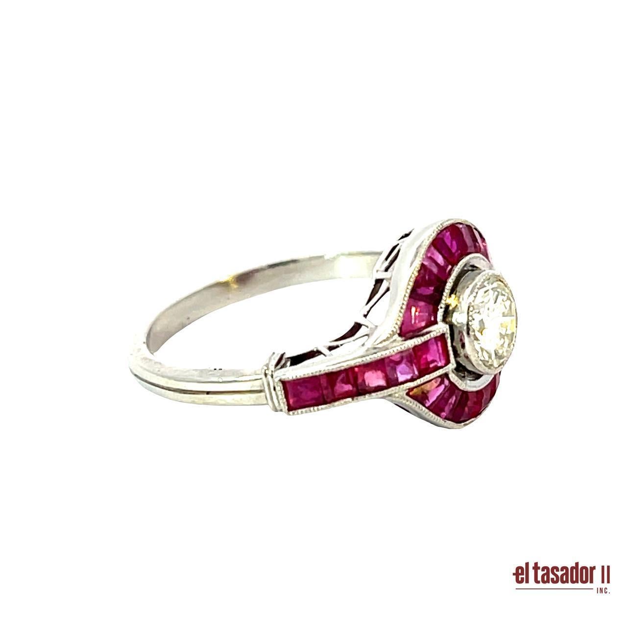 Questo splendido anello Art Deco in platino presenta un brillante diamante rotondo da 0,55 carati circondato da 3,32 carati di vividi rubini dal taglio calibré. Il design geometrico a raggiera, emblematico dell'epoca degli anni '20, mette in risalto