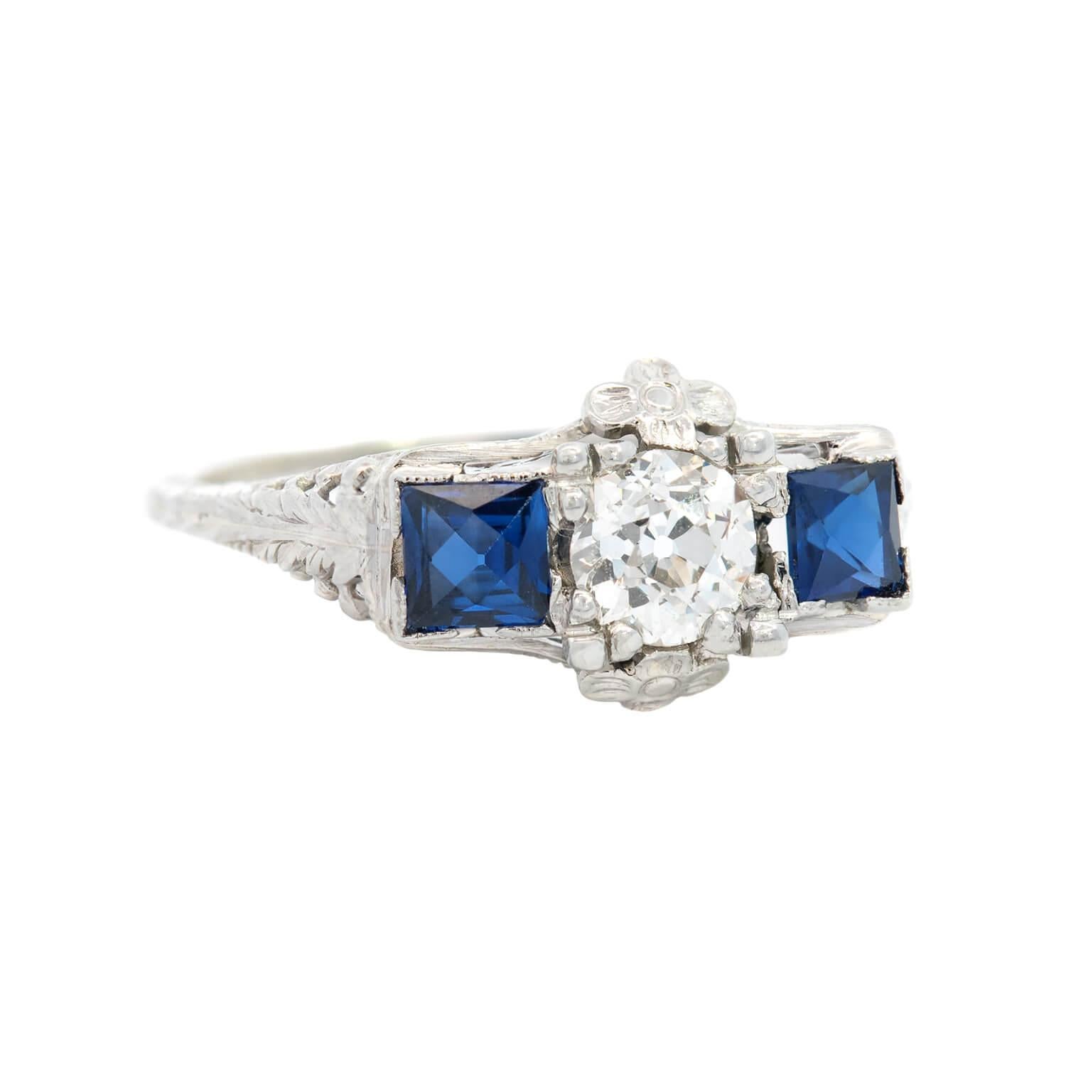 A beautiful diamond and sapphire ring from the Art Deco (ca1930s) era! This gorgeous piece is crafted in platinum and features three stones running horizontally across the front of the ring. The central stone is an old mine cut diamond, which is