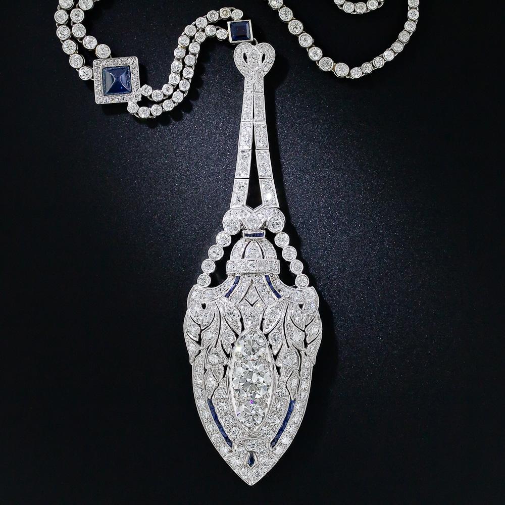 This enchanting Art Deco lavaliere necklace stunningly exemplifies the lavish and sophisticated style of the roaring twenties. The 3 and 1/2 inches-long lavaliere pendant is fashioned as a highly styled, neoclassical amphora and culminates in a trio