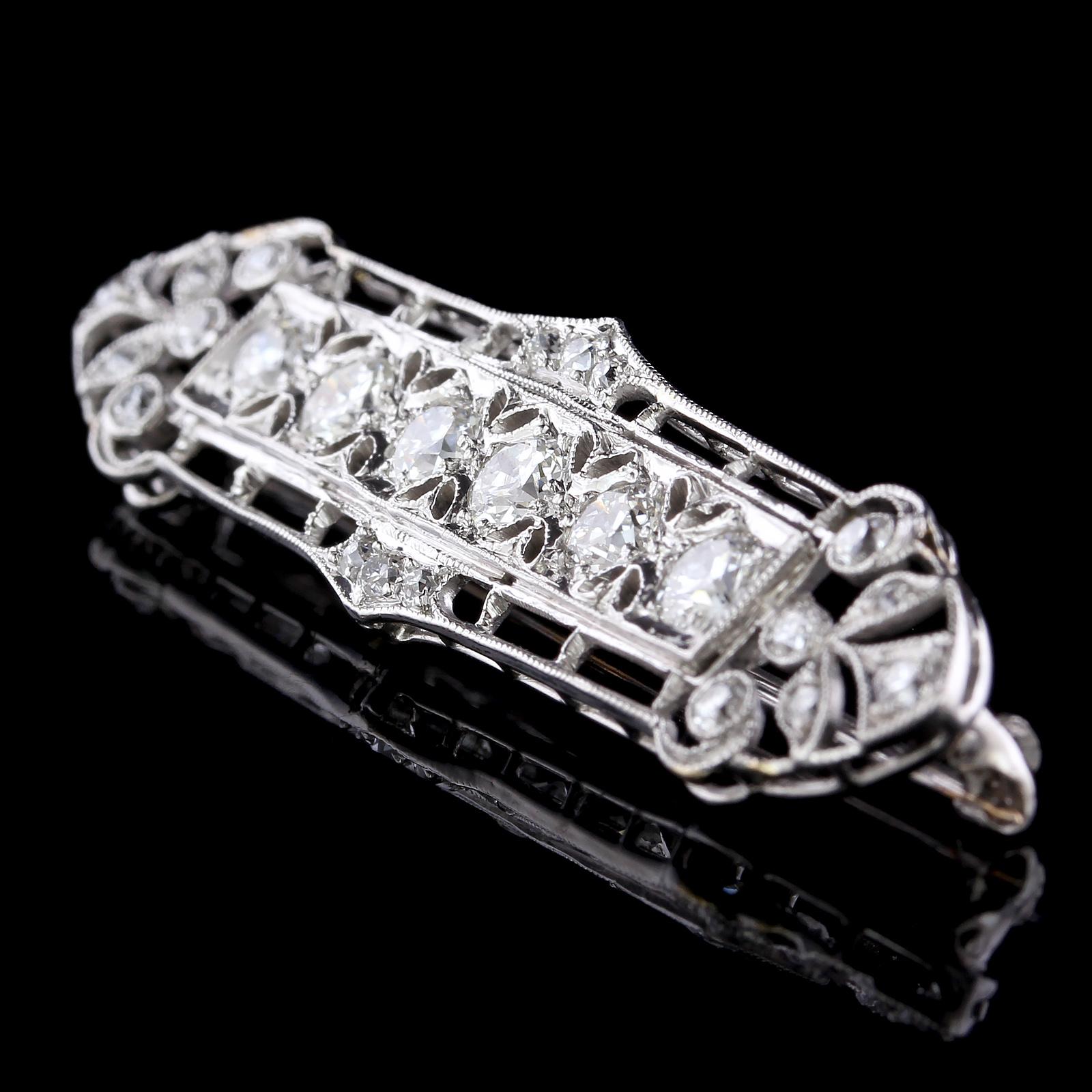 Art Deco Platinum Diamond Bar Pin. The pin is set with six old European cut
diamonds, approx. total wt. 1.00cts., further set with 18 old European cut and
old mine cut diamonds, approx. total wt. .50cts., I color, VS clarity, length 2