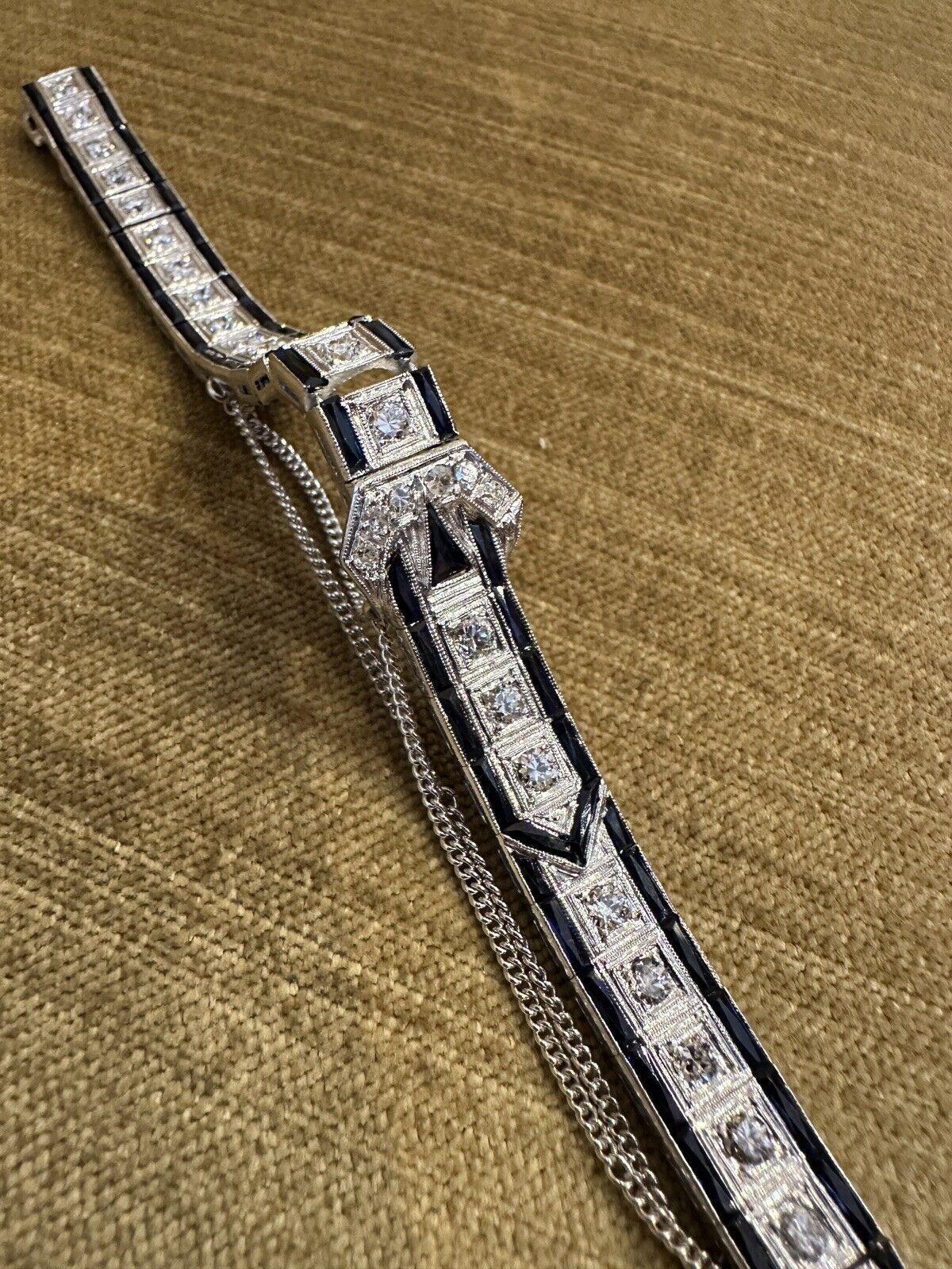 Art Deco Platinum Diamond Buckle Line Bracelet 

Platinum Art Deco Line Bracelet features a single row of 31 Old Cut Round Diamonds and Faceted Blue Stones, possibly synthetic or natural sapphires, on either side with a Buckle Design in center all