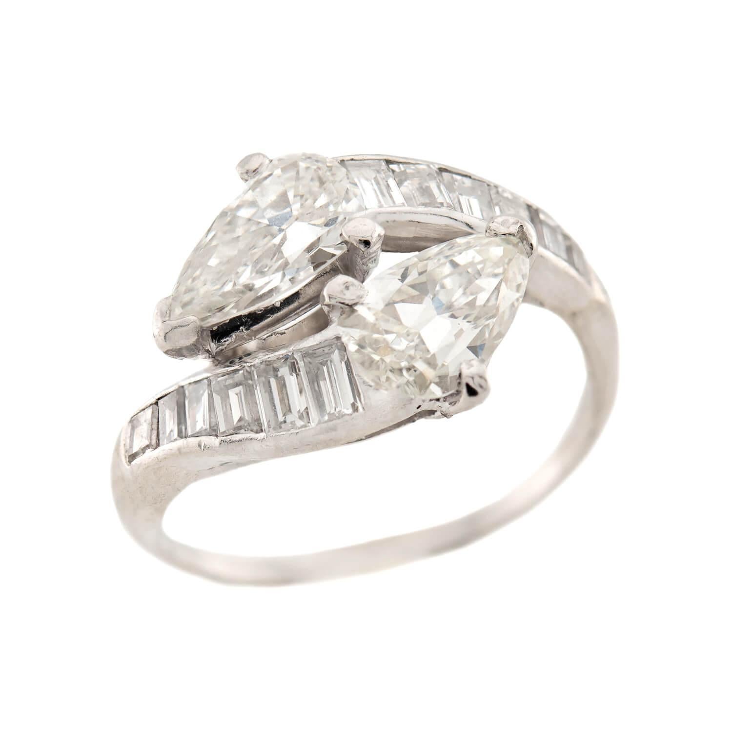 A spectacular diamond bypass ring from the Art Deco (ca1920s) era! Crafted in platinum, this ring features two pear cut diamonds, which are held within three-prong settings. The two diamonds are nestled together and create a wonderful bypass design,