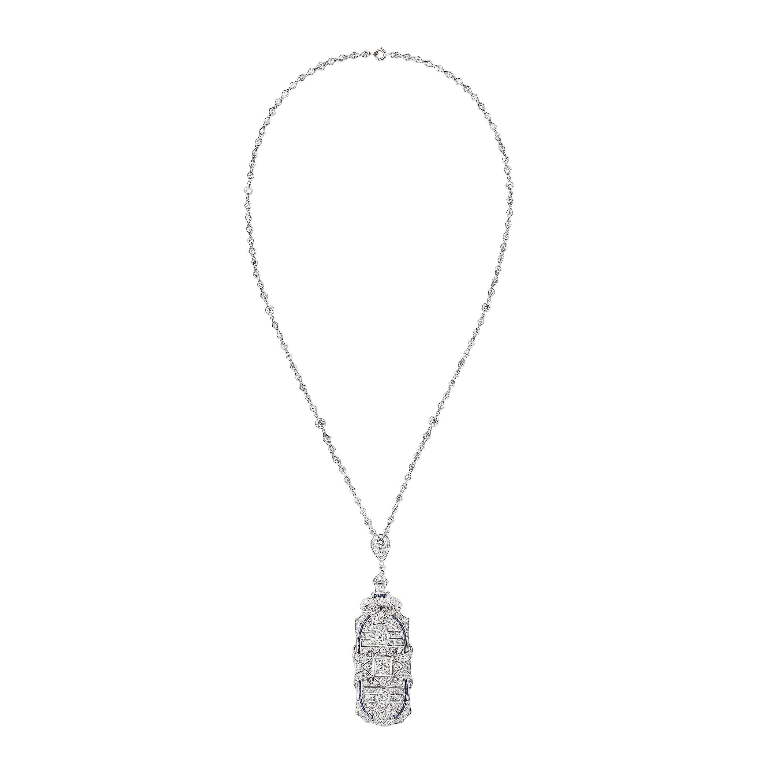 This exquisite Art Deco platinum and diamond chain pendant/brooch, crafted in the United States, circa 1925, exemplifies the era's elegance and innovative design. The intricate piece features 2 old European-cut diamonds totaling approximately 0.70