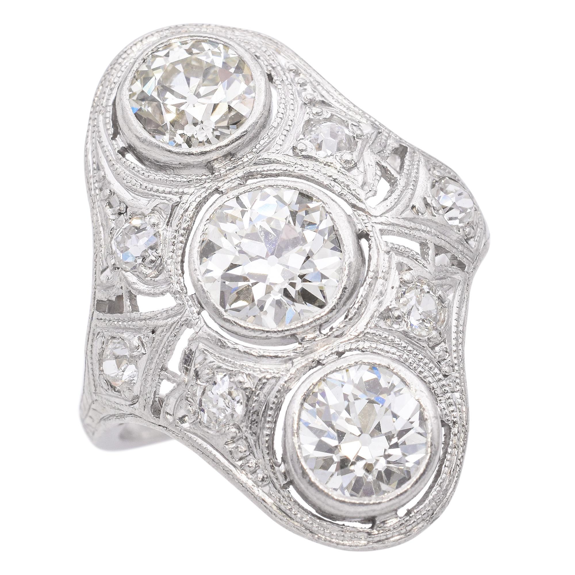 Questo anello da cena in platino Art Deco presenta tre splendidi diamanti taglio old mine, incastonati in un design audace ed elegante. Gli intricati dettagli in platino riflettono il fascino geometrico dell'epoca, aggiungendo raffinatezza vintage e