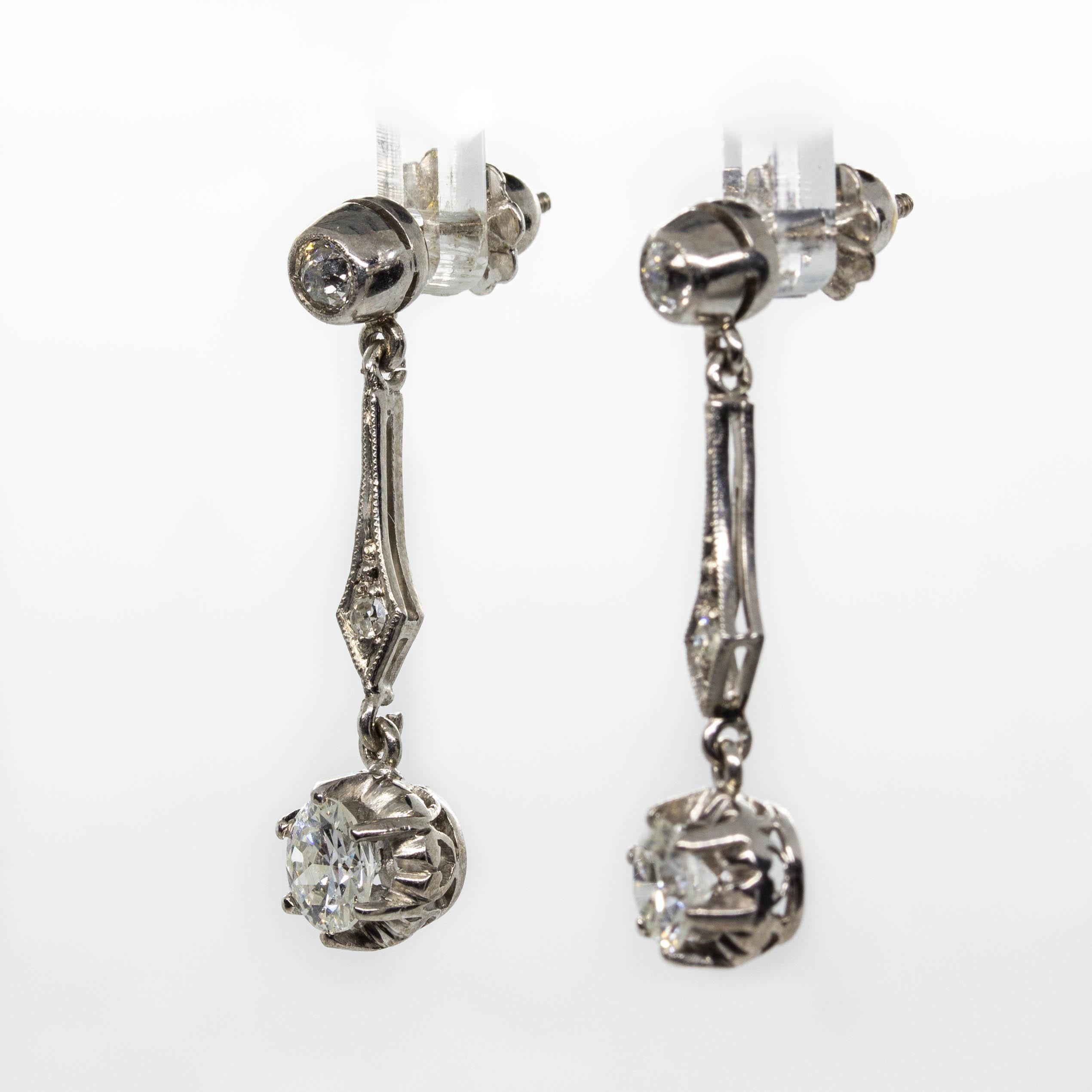 Dating back to the Art Deco period, this scintillating pair of earrings culminate in a pair of old European cut diamonds of H-VS2 quality together weighing 1.20ctw (0.60 each.)
The central stones suspend from a pair of old European cut diamonds of