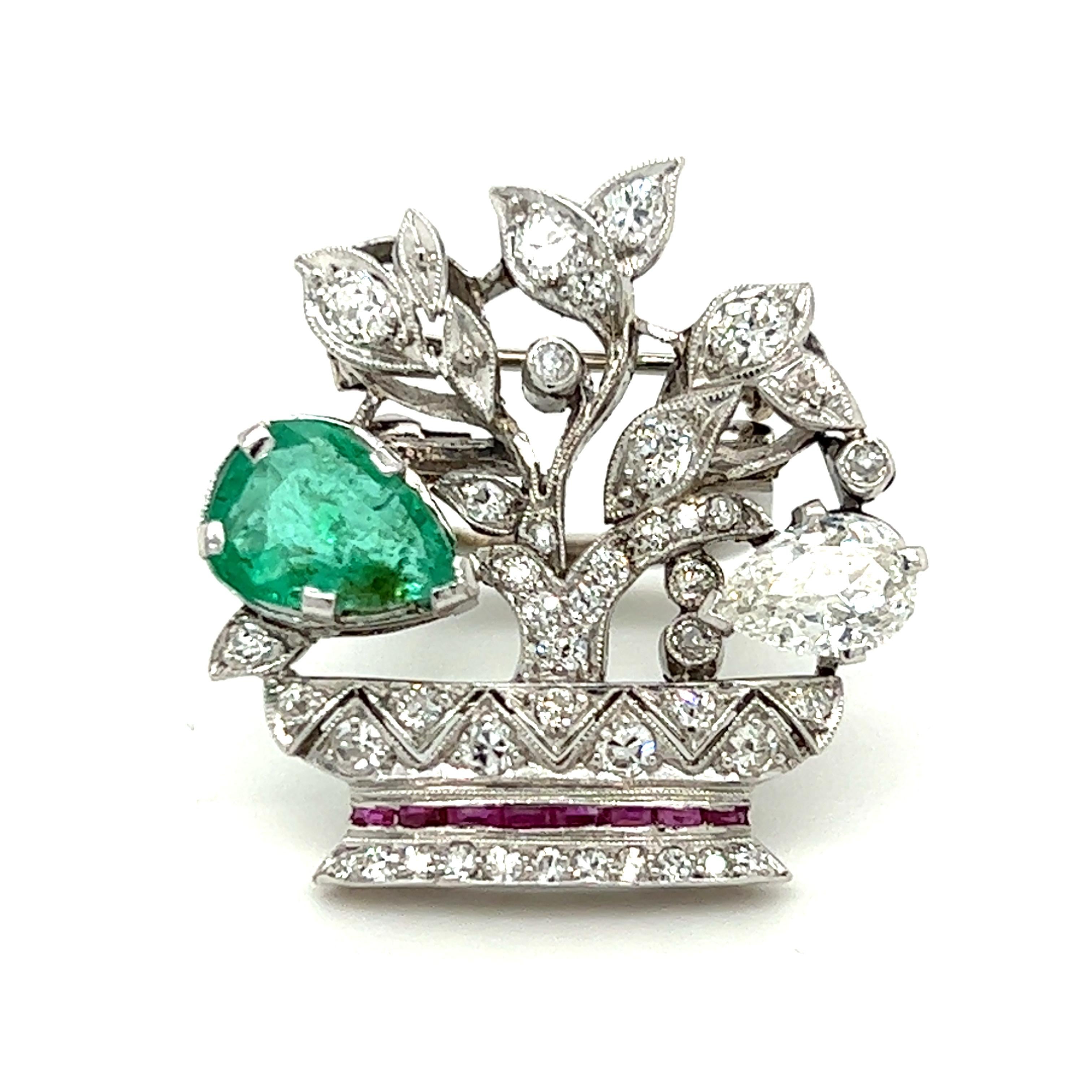 One platinum Art Deco clip brooch in a plant design set wit one (1) 9x7mm pear shaped emerald, one (1) 2x5.5mm pear shaped diamond with K/L color and I1 clarity, forty-one (41) small old mine cut diamonds, approximately 1.00 carat total weight with