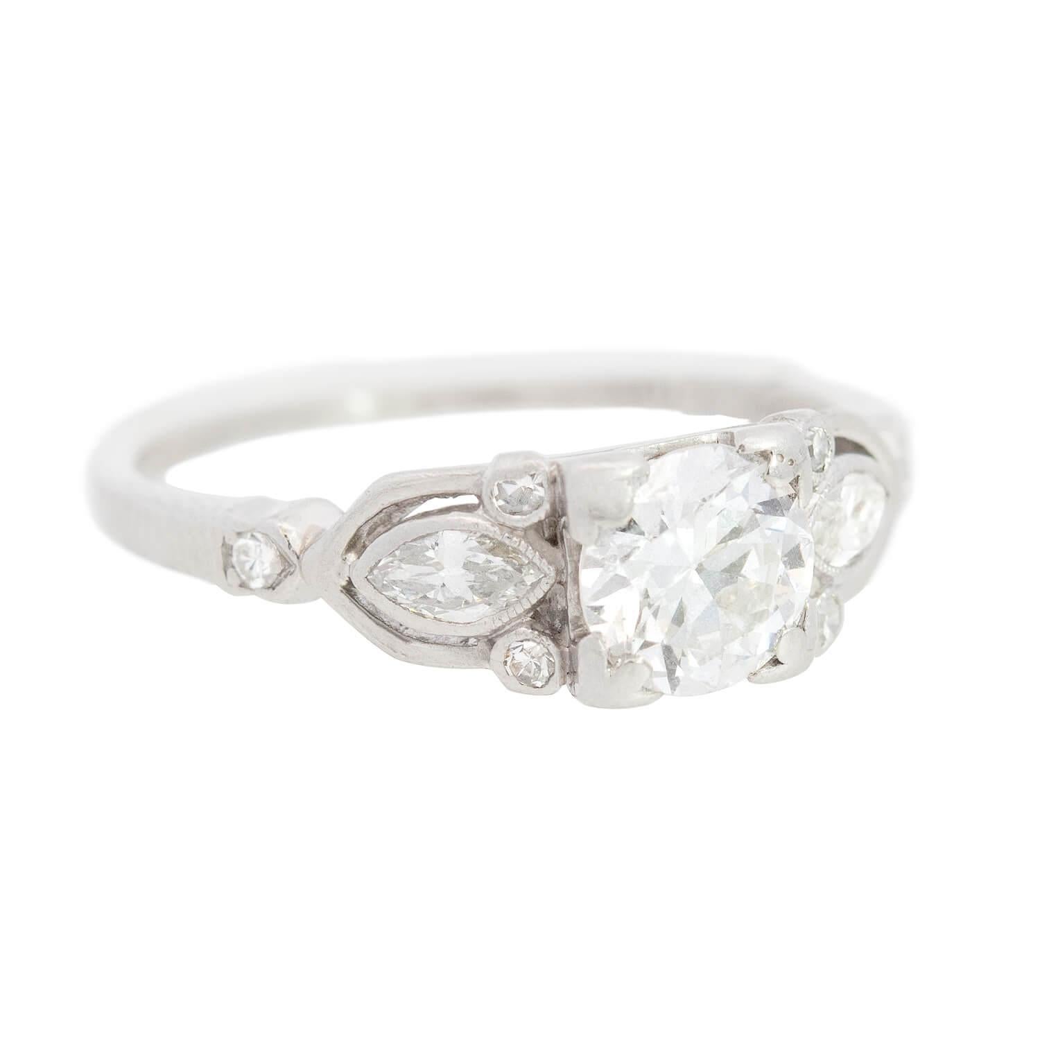 A beautiful diamond engagement ring from the Art Deco (ca1920) era! Made of platinum, this stunning ring has a unique mounting that holds a 0.70ct old European Cut diamond at the center. The diamond rests in a square prong setting and has H/I color