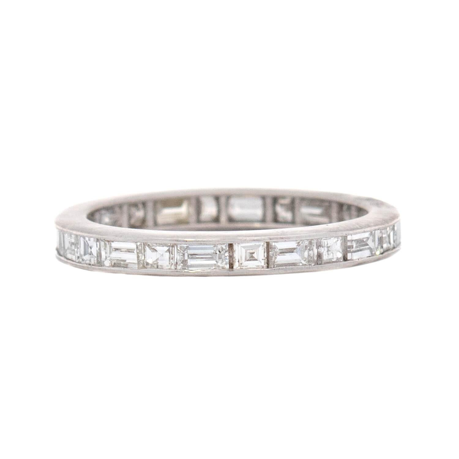 A gorgeous diamond eternity band from the Art Deco (ca1920) era! Crafted in platinum, this ring features 1.35ctw of baguette and square cut diamonds resting within a channel setting. The top and bottom edge of the band are smooth and simple. An
