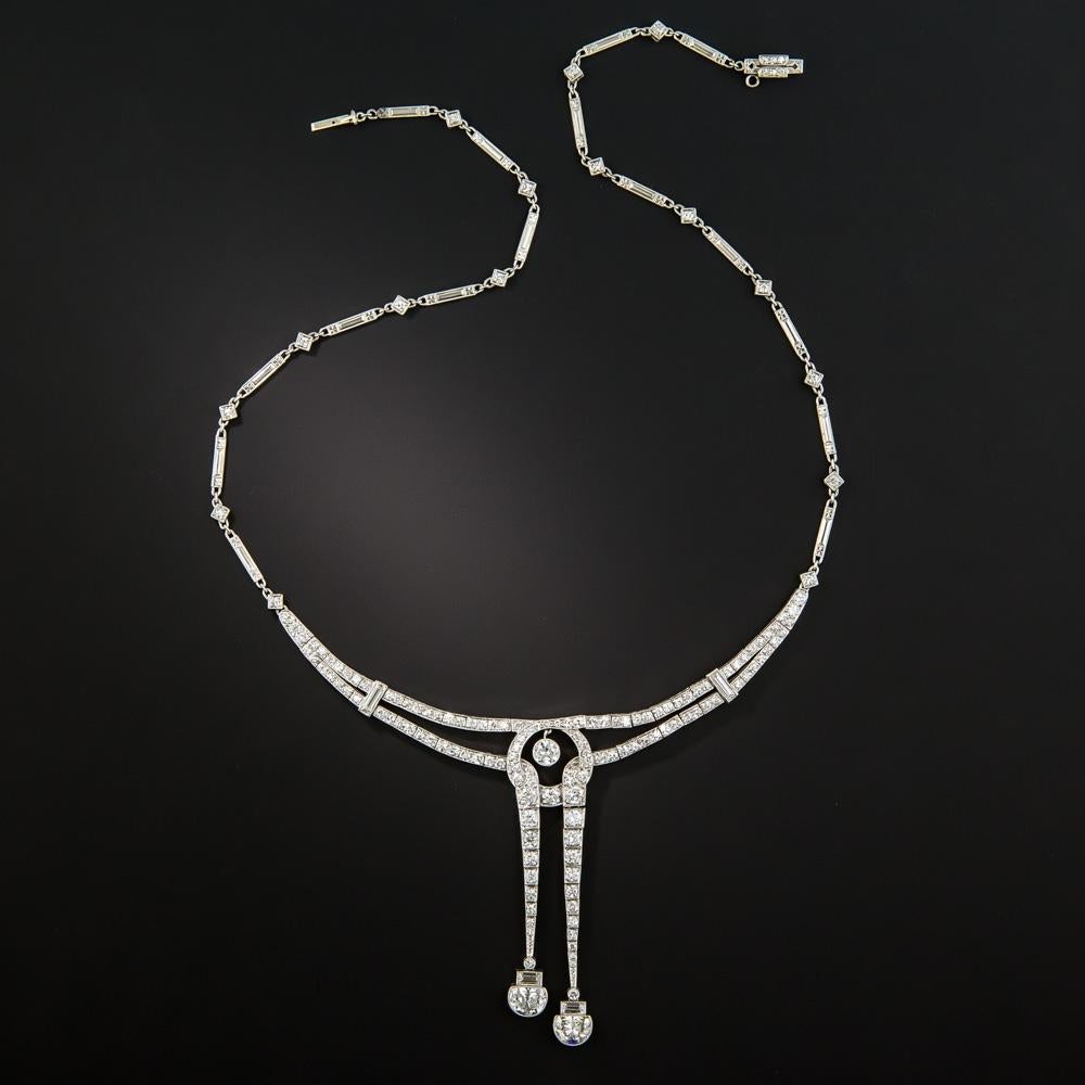 Hailing from the peak of the Jazz Age, circa 1925, this slinky, sexy vintage sparkler combines Art Deco aesthetic  with a classic negligee necklace motif. Instead of the usual pair of round diamonds, the asymmetrical lavallière section culminates in