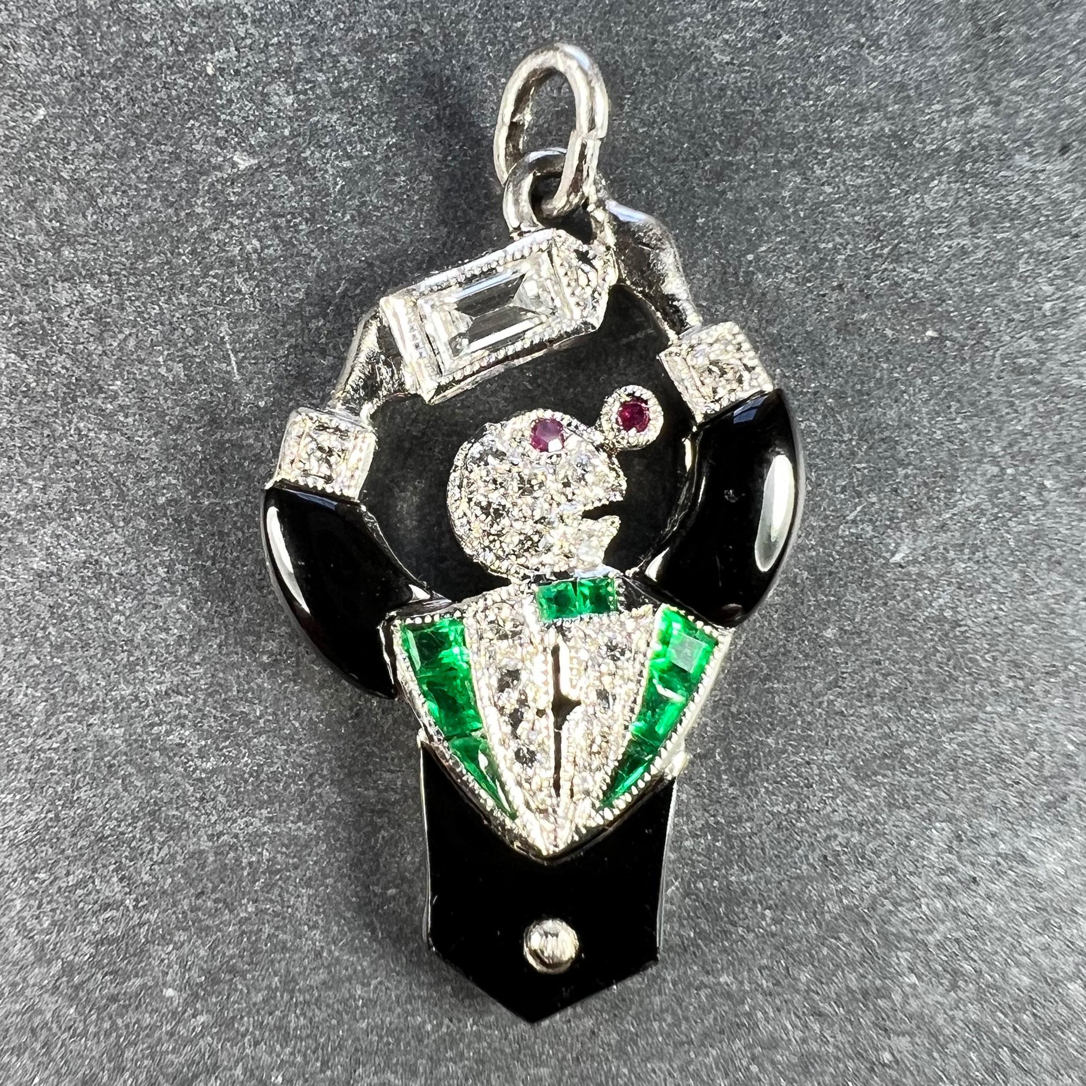 An Art Deco platinum charm pendant designed as a cocktail waiter or bartender mixing a martini or similar drink. Set with carved onyx to represent the jacket, one emerald cut diamond and 13 round brilliant cut diamonds with a total estimated weight