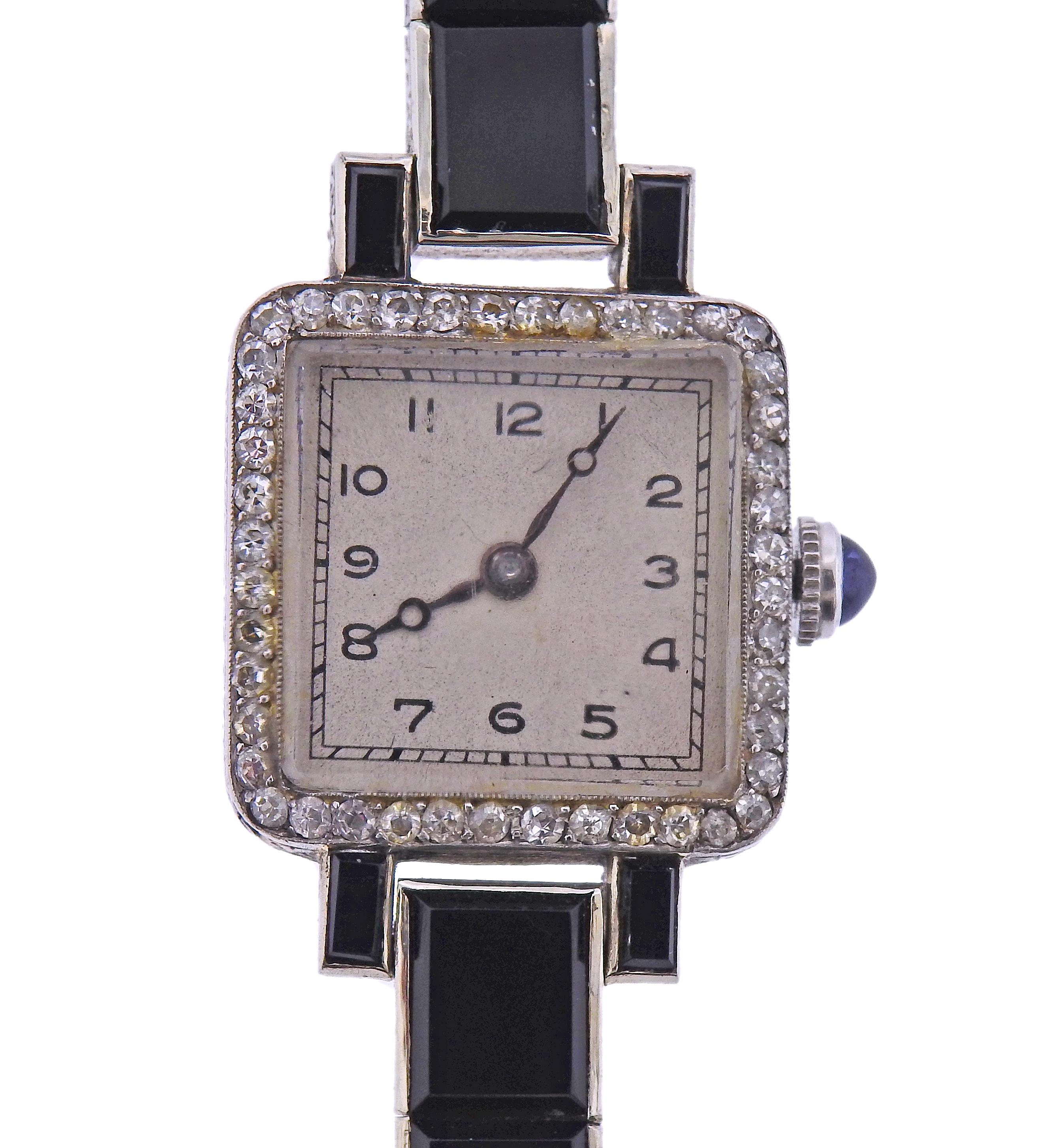 Iconic Art Deco platinum lady's watch, decorated with onyx, diamonds and blue sapphire crown. Manual wind movement in working order. Bracelet is 6.5