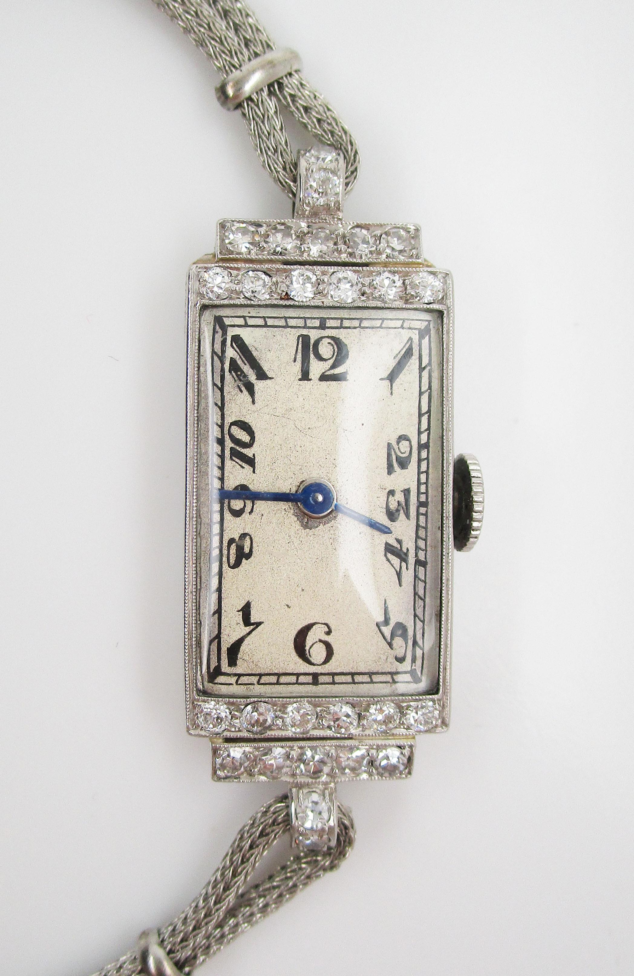 This is a gorgeous Art Deco watch with a platinum case accented with a gorgeous array of bright white diamonds. The watch has a platinum case with beautifully engraved floral details on the sides. The top of the case is set with bright white