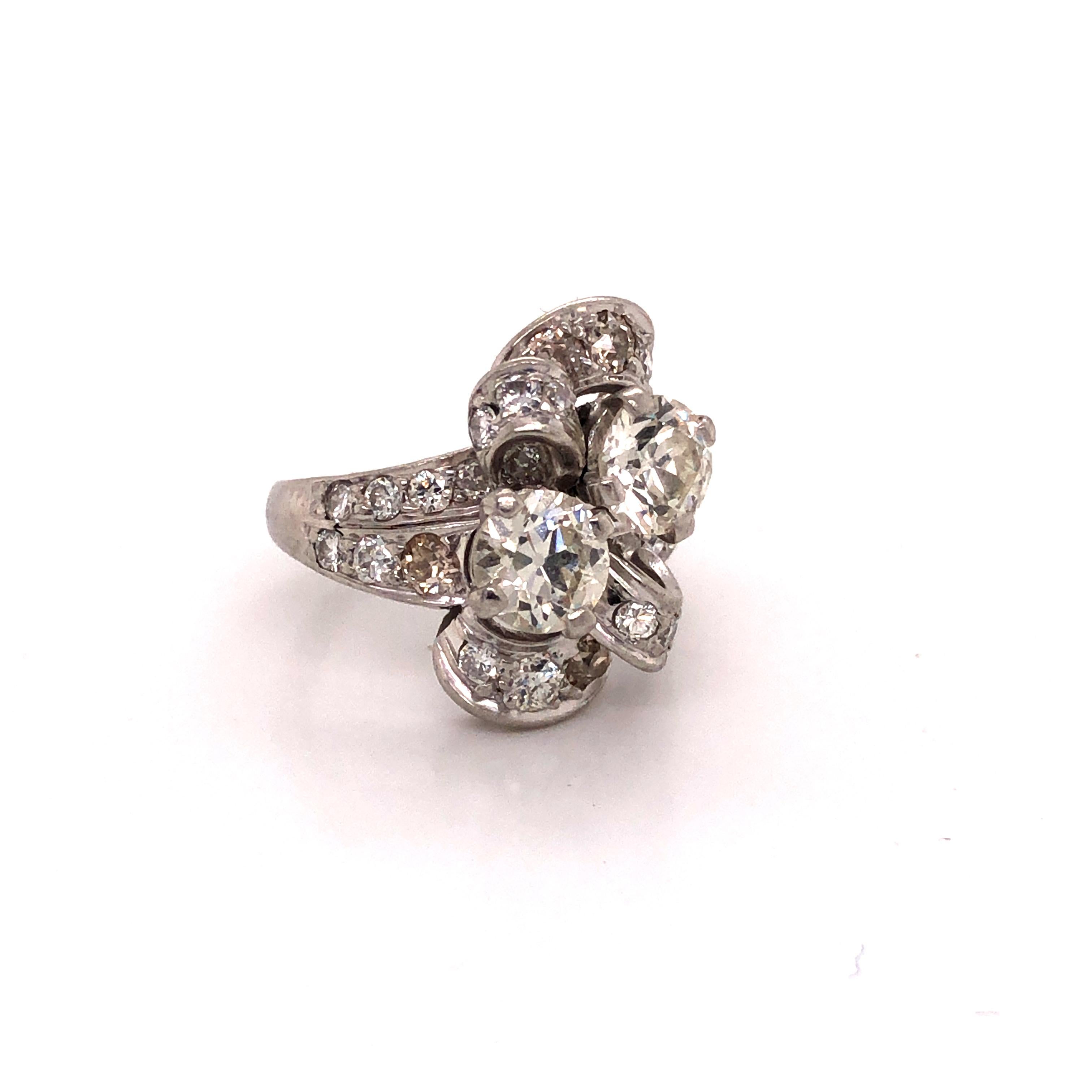 Amazing creation from the 1920s. This ring is hand crafted in platinum with beautiful Old European cut diamonds set throughout. The focal point of the ring are the two center stone diamonds. Each individually weighing approximately 0.60 ct. these