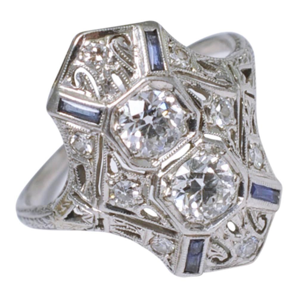 Gorgeous Art Deco platinum and diamond ring with baguette sapphire accents by Peacock, USA; the two main diamonds are Transitional cuts and weigh 1ct with further 8-cut diamonds decorating the ring.  It is slightly shaped to fit the finger