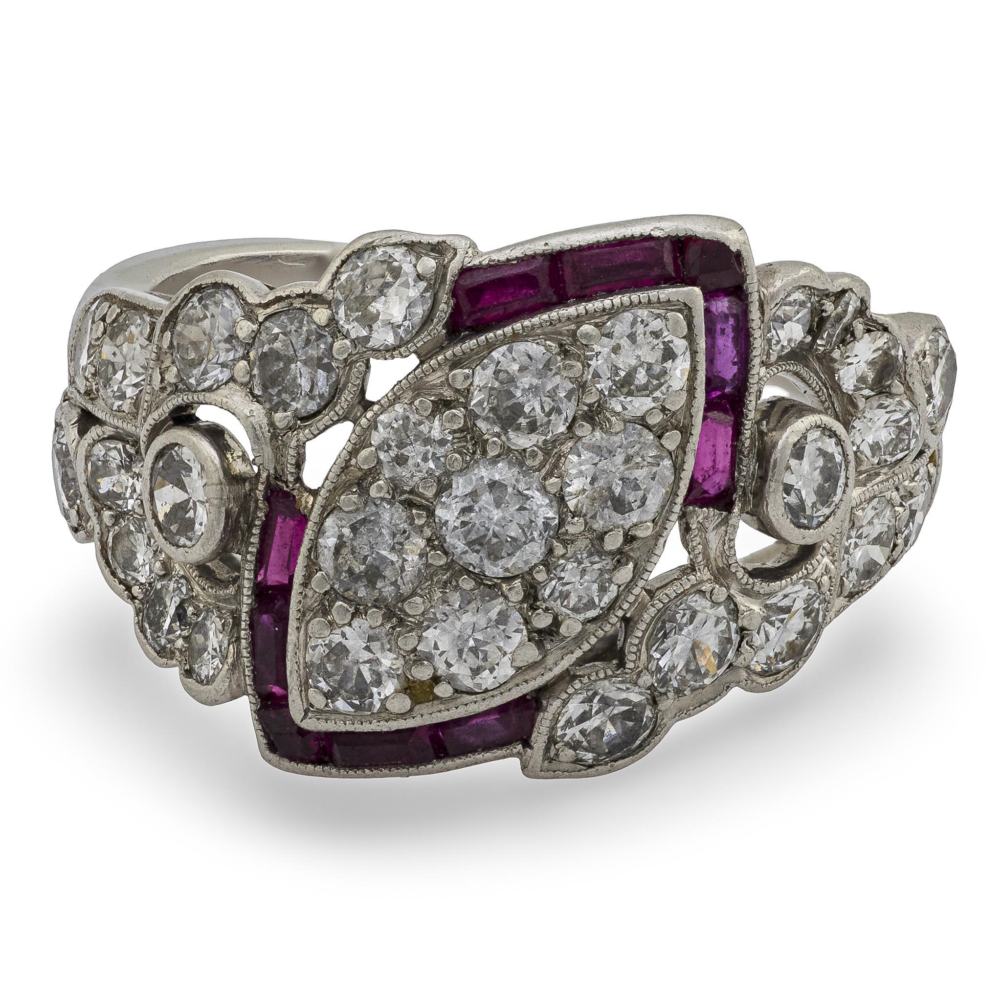 Une bague unique en diamant et rubis de l'époque Art Déco (ca1920s) ! Réalisée en platine, cette bague présente sur le devant un centre en forme de marquise, incrusté de diamants taille ancienne sertis en perles. Les diamants sont bordés d'un cadre
