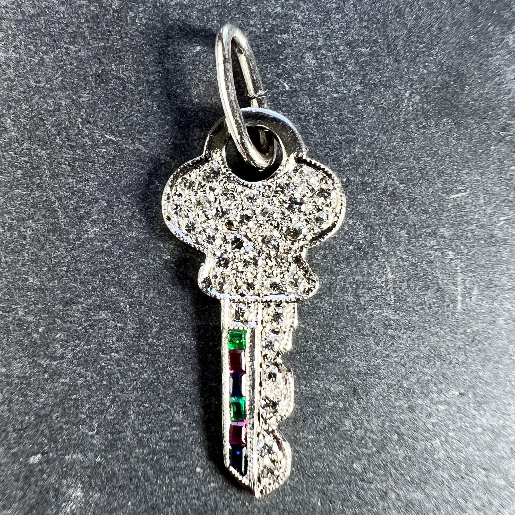 An Art Deco platinum charm pendant designed as a key set with 33 round brilliant cut diamonds with a total estimated weight of 0.50 carats, 2 step cut emeralds with a total estimated weight of 0.04 carats, 2 step cut rubies with a total estimated