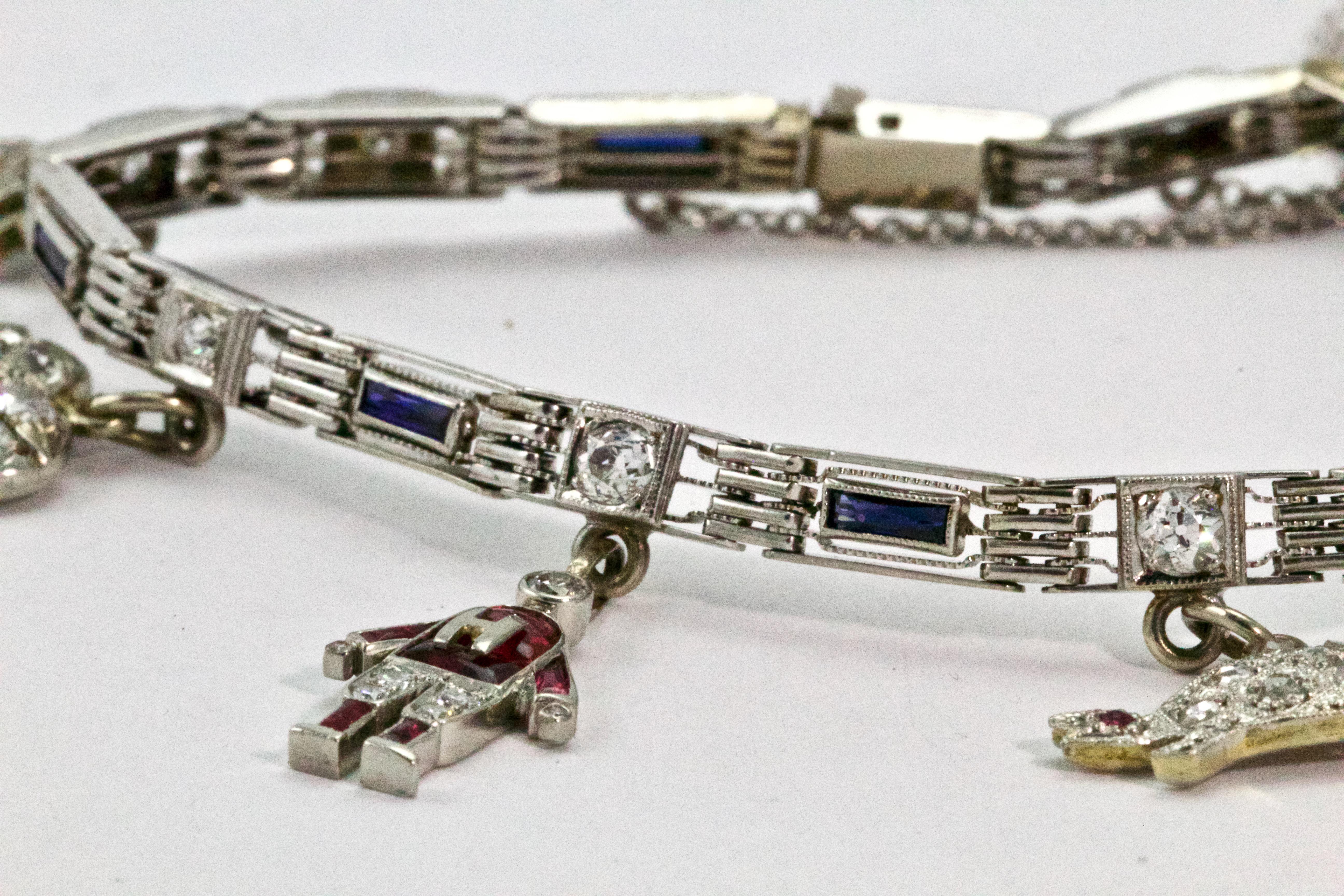 A fine example of an Art Deco charm bracelet with unique and fun charms. The bracelet is composed of platinum gate style links and set itself with baguette cut sapphires and old mine cut diamonds, it is host to 7 wonderful antique charms consisting