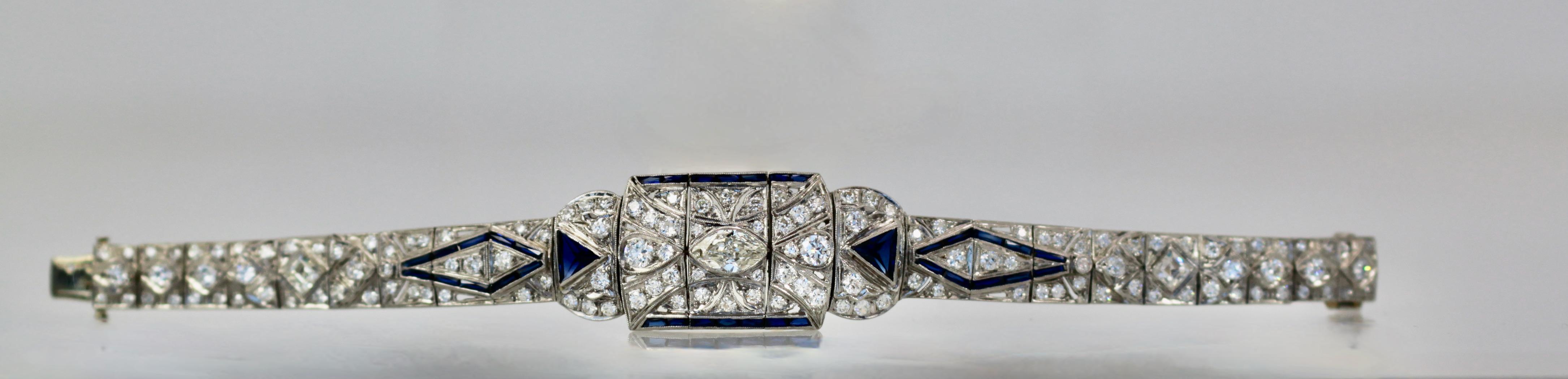 This gorgeous Art Deco Platinum Bracelet is covered in Diamonds mostly round but also it has a center marquise Diamond.  There are 86 round Diamonds and 22 true Blue Sapphires.  The largest Diamond is the center .50 and three center Diamonds of