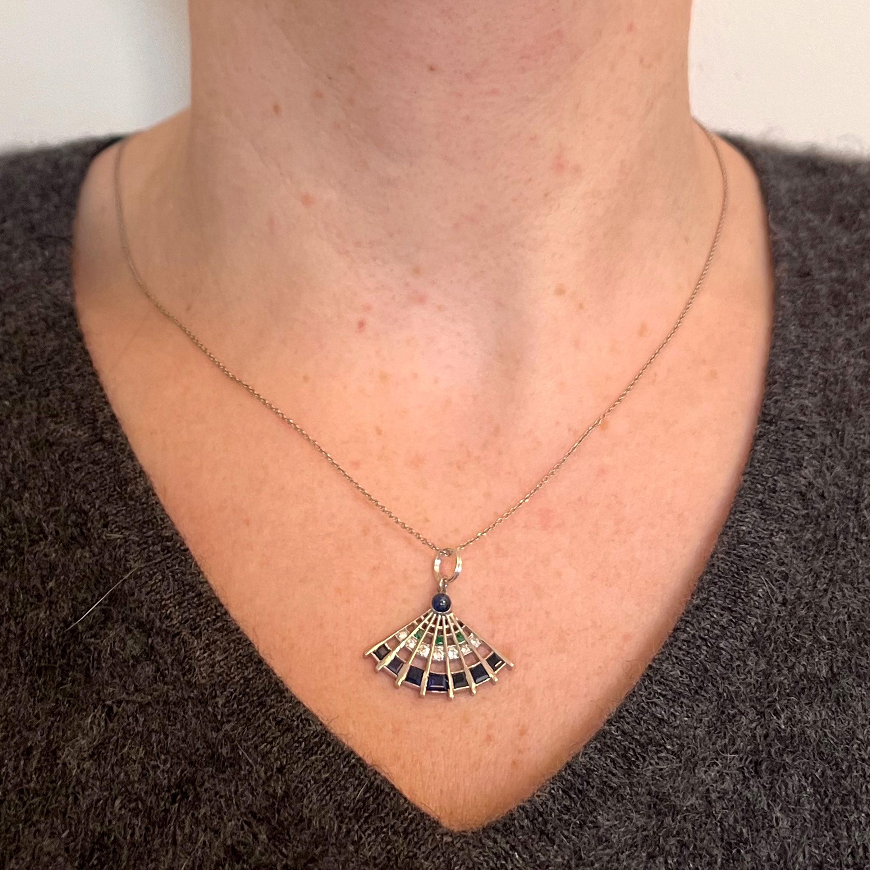 An Art Deco platinum charm pendant designed as a lady’s fan set with sapphires, emeralds and diamonds. Unmarked but tested for platinum.
Sapphire weight: 1.10 carats (estimated)
Diamond weight: 0.07 carats (estimated)
Emerald weight: 0.03 carats