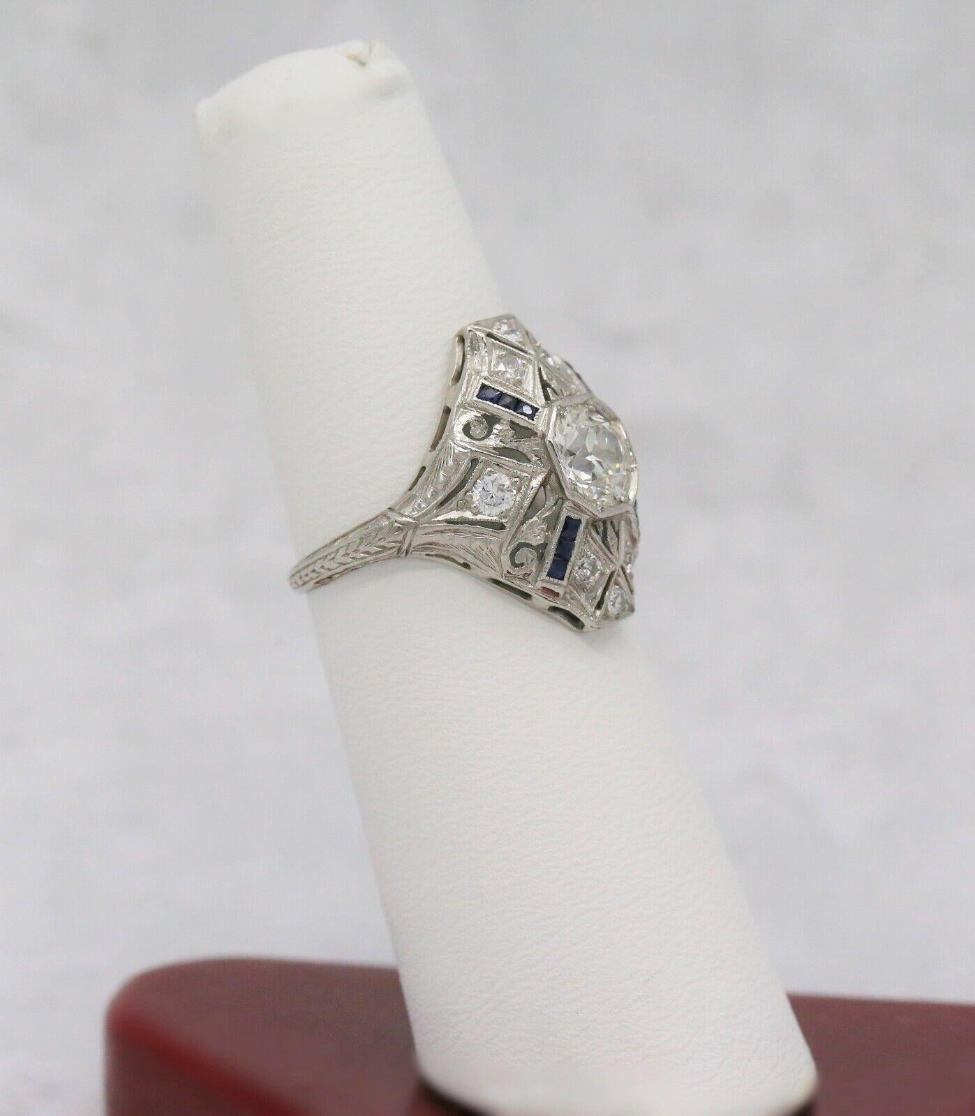 The bold style of this art deco ring breaks away from fluid lines and reflects in the mosaic designs of the era. Beautifully hand crafted in platinum, this ring features a large bezel set European cut diamond in the center. The four rows of channel