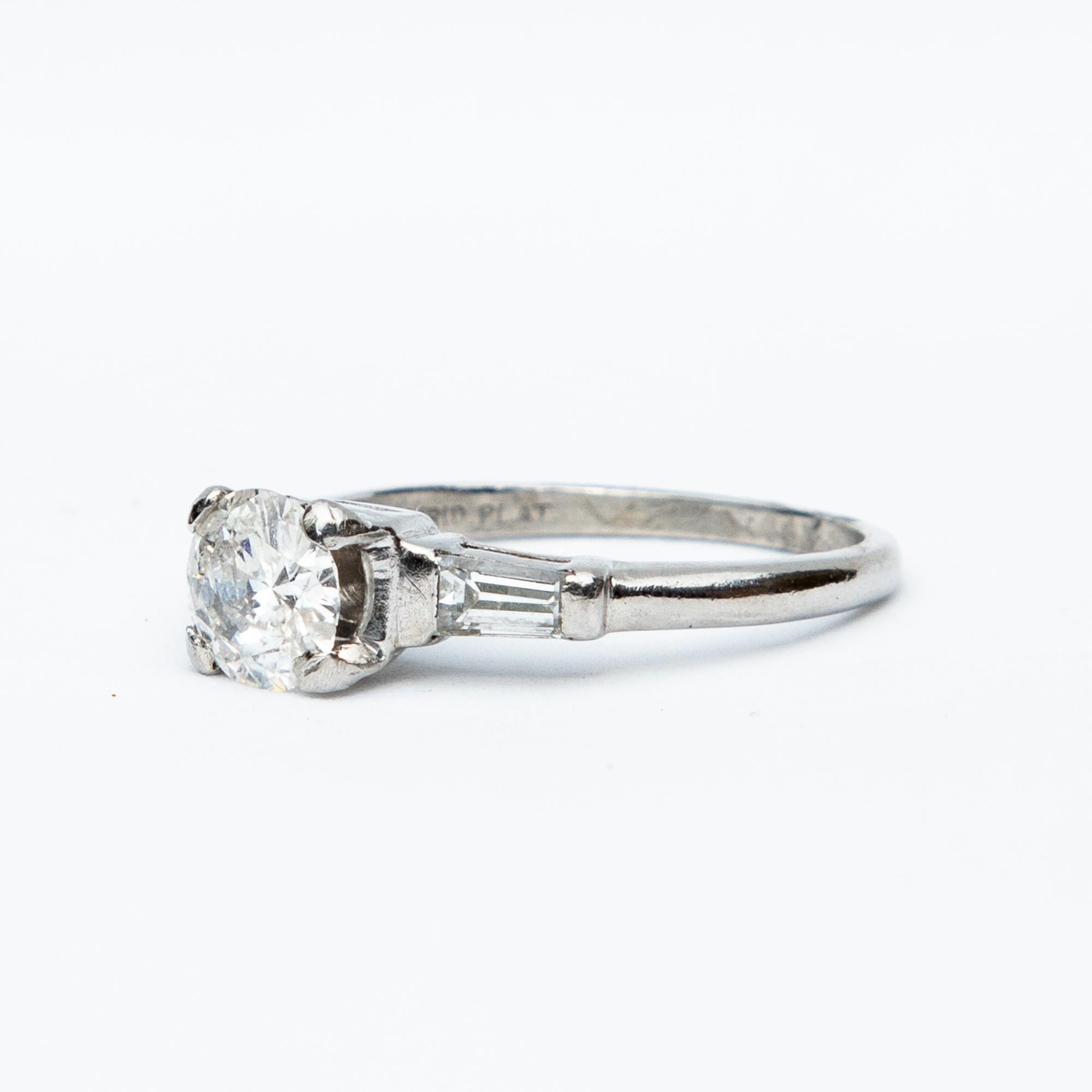 This beautiful diamond solitaire ring boasts a central diamond with tapered baguette diamond shoulders. Total diamond weight certified 1.05 carats, G/I colour and clarity VS2.

Size: N or 6.45

Certification included
