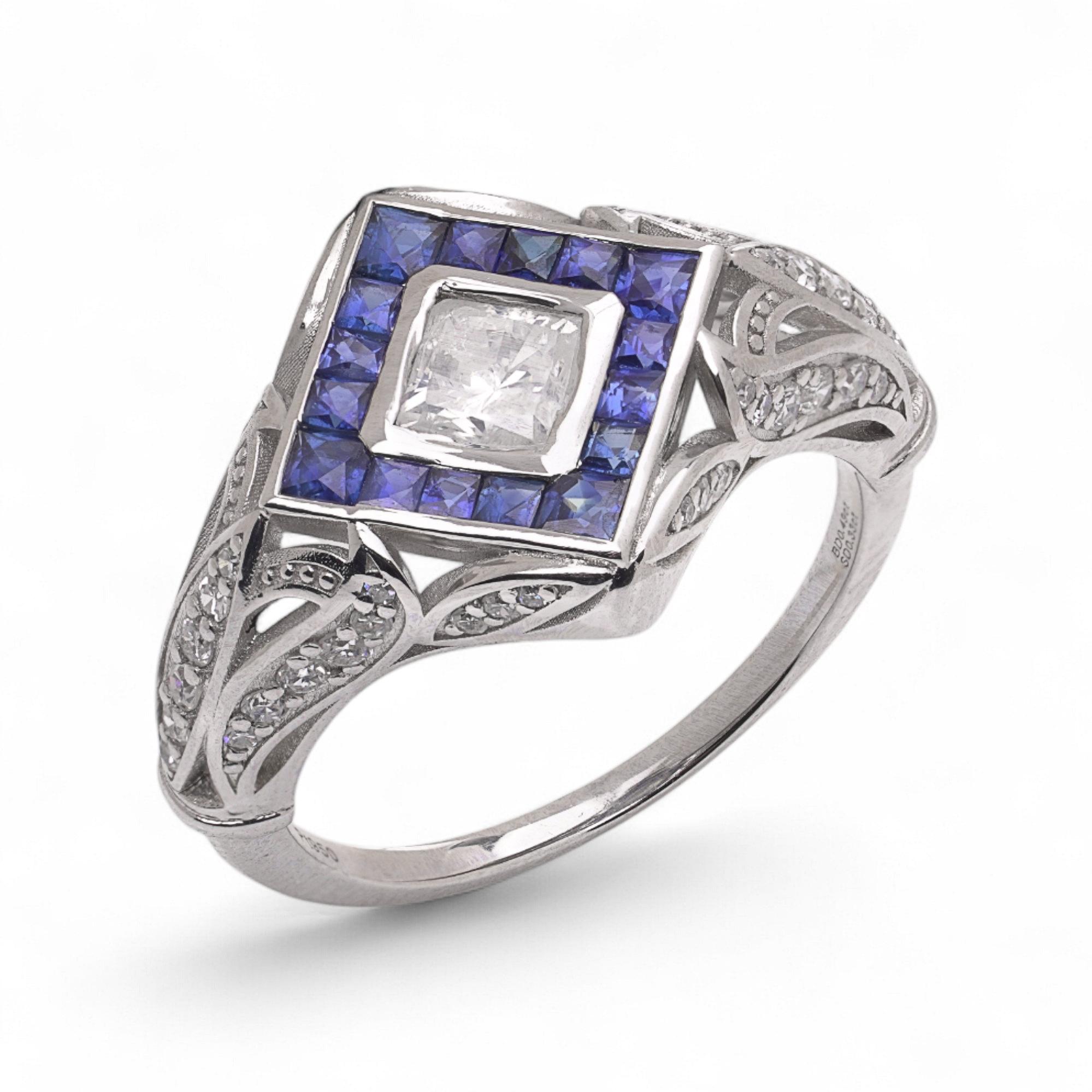 Art Deco Platin Diamant Solitär Ring

Ein eleganter Platinring mit einem zentralen Diamanten, der von weiteren Brillanten umrahmt und mit farbintensiven Saphiren im Quadratschliff akzentuiert ist. Das kühne und doch raffinierte Design schafft ein