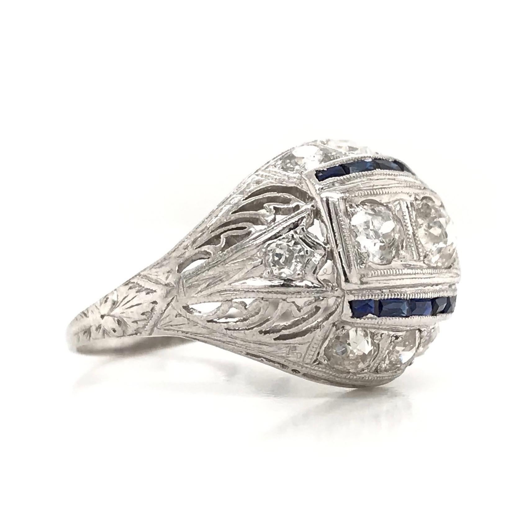 This antique piece was handcrafted sometime during the Art Deco design period ( 1920-1940 ). This exquisite antique ring is full of charming details and is quite exemplary of the wonderfully creative design period. The ring features 10 sparkling