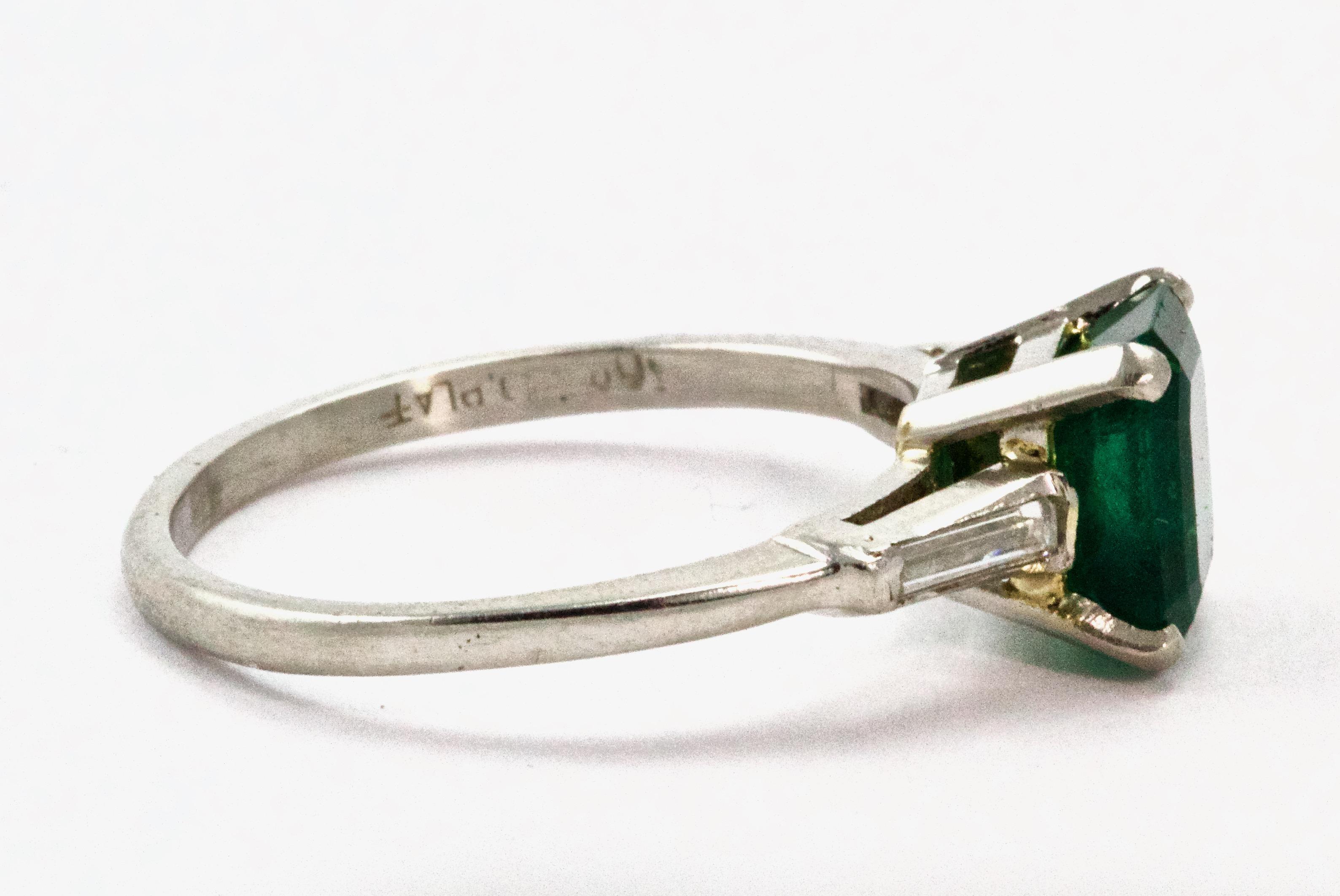 A beautiful Emerald and Diamond engagement ring, modeled in platinum throughout. Set with a natural 1.5 Carat emerald to the center in four claw setting, while delicate tapered baguette diamonds flank the emerald.
Dimensions 
Emerald: 7mm
Ring Size: