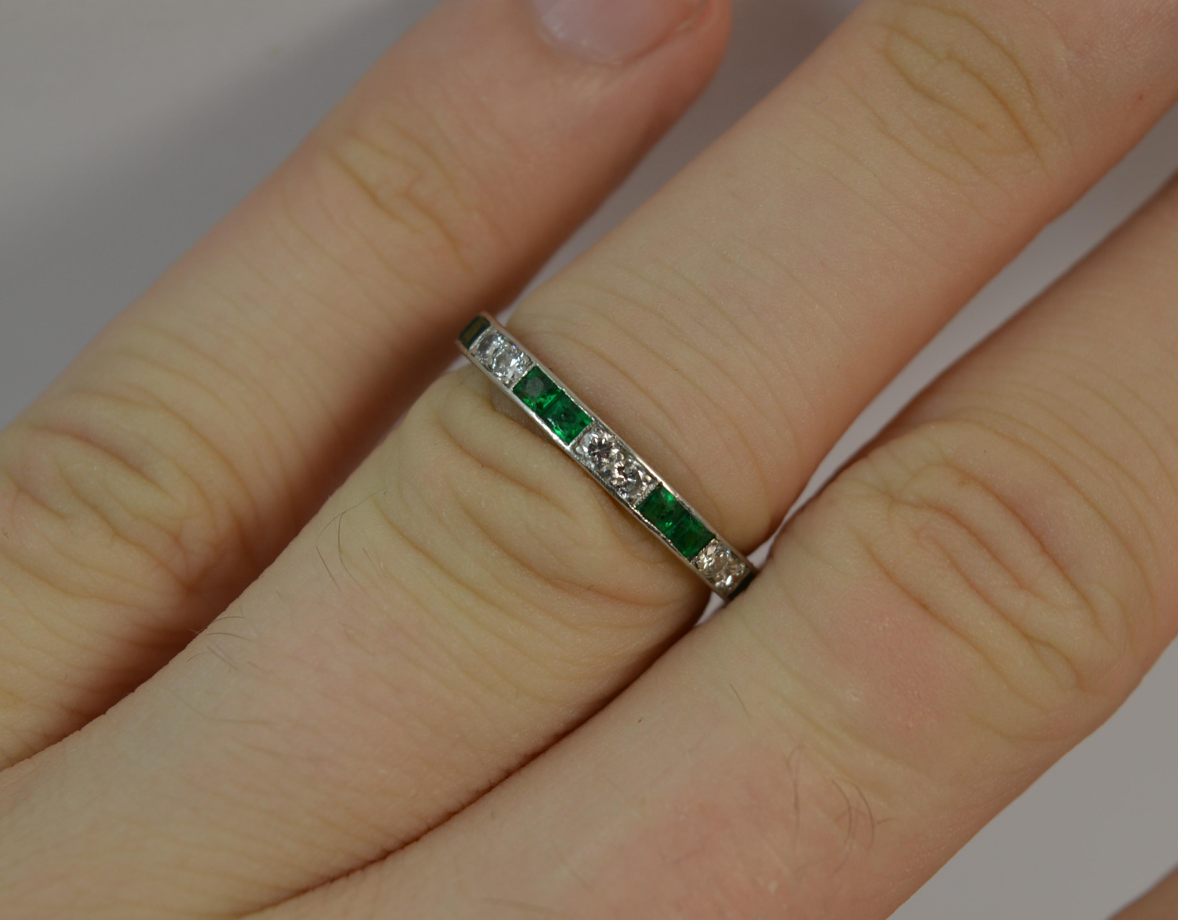 A stunning ladies full eternity ring. Solid platinum ring. Set with princess cut natural emeralds and round cut diamonds in alternating sections. 2.35mm thick band throughout, protruding 1.65mm off the finger. True Art Deco period piece, circa