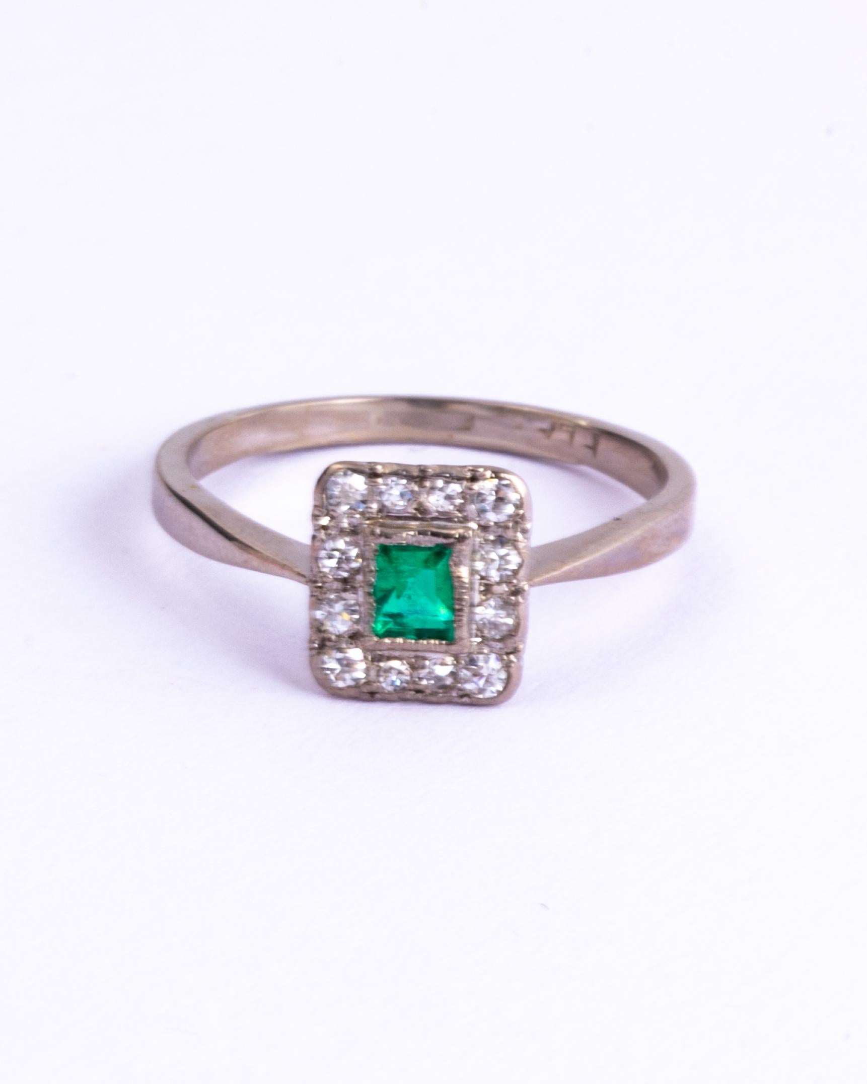 A superb antique Art Deco panel ring centrally set with a classic emerald-cut green emerald. The emerald is bordered by twelve beautiful old European cut white diamonds totalling aprox 25pts. The stones are set in platinum to complement their