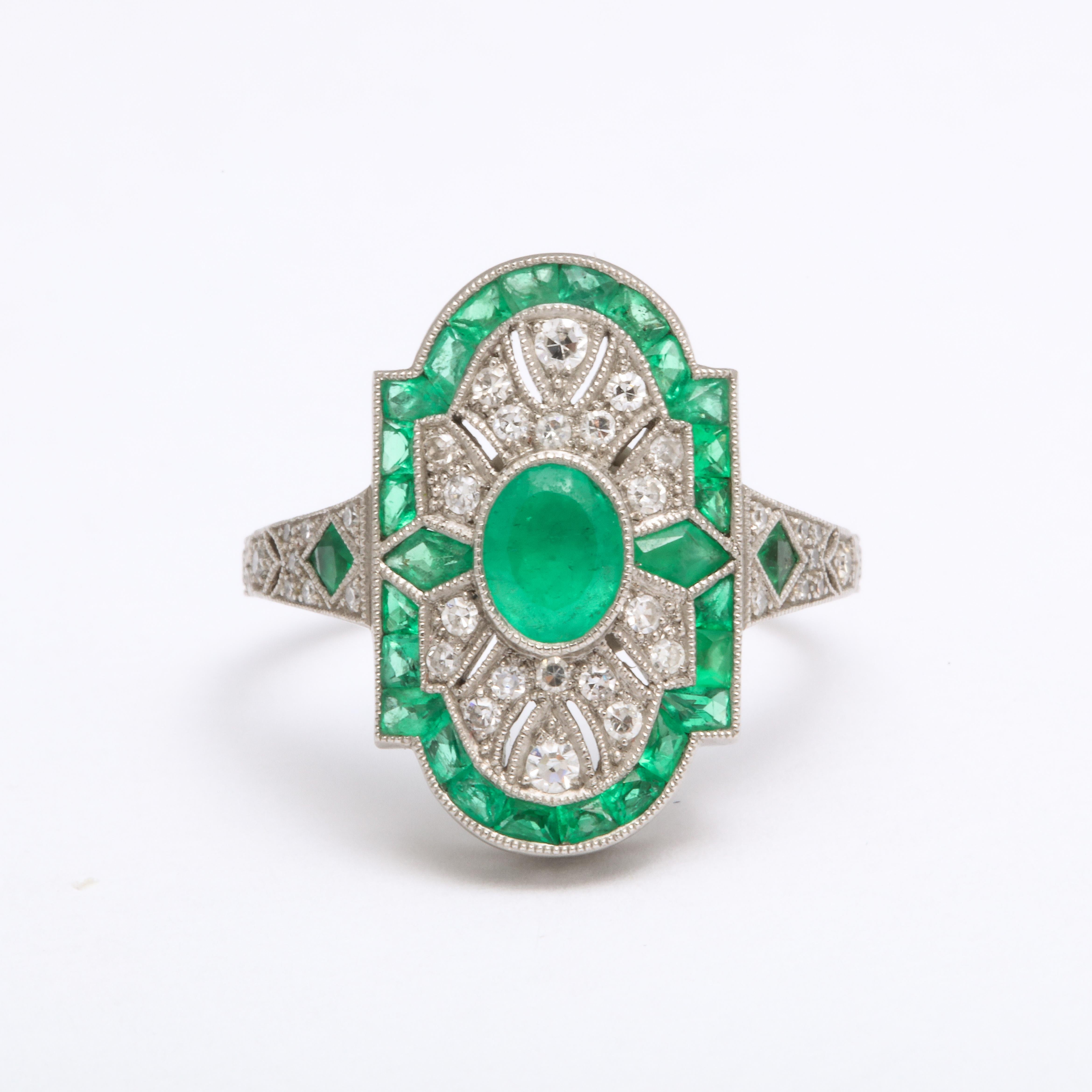 Like a breath of fresh air, or freshly cut grass, your senses absorb the green of the emeralds in this beautiful, hand made emerald, diamond Art Deco style ring. The gems are mixed cuts, oval at center, kite on either side of the oval, cabriolet