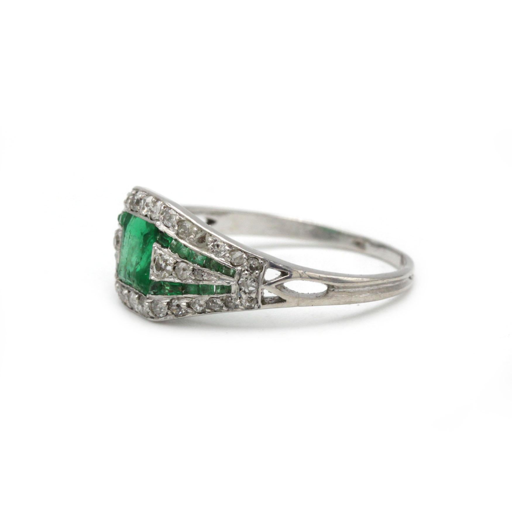 A beautifully sculptural Art Deco ring crafted in platinum, featuring a central square-cut emerald flanked and framed by brilliant-cut diamonds in a geometric, openwork setting.

Technical Sheet

Attribute	Details
Period / Style	Art Deco (c.