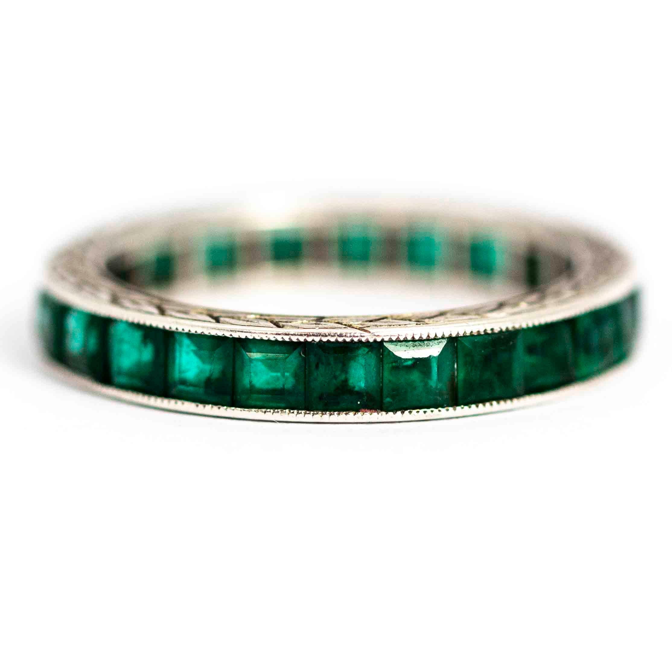 A superb vintage Art Deco eternity band ring fully set with wonderful square cut emeralds. The edges of the band are hang-chased with beautiful foliate detailing. Modelled in platinum

Ring Size: UK K 1/2, US 5

Band Width: 3.22mm

Depth to Finger: