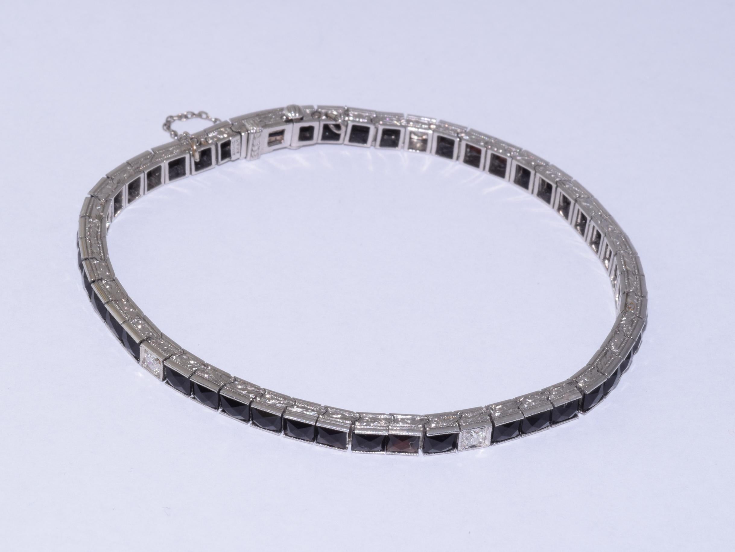 Ce bracelet de ligne Art déco classique présente 45 onyx de taille française accentués de 5 diamants de taille européenne ancienne totalisant environ 0,25 ct, montés en platine avec numéros et date de brevet 1922. Le bracelet mesure environ 6,7