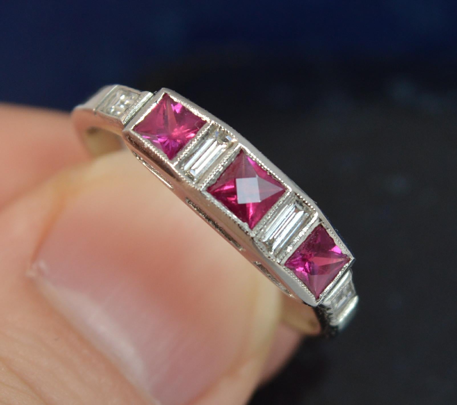 A stunning Art Deco design Ruby and Diamond ring.
Ring Size; N 1/2 UK, 7 US
Modelled in 950 grade solid platinum.

Designed with three French cut rubies of vivid bright pink red stones with a baguette cut diamond in between and a further diamond to