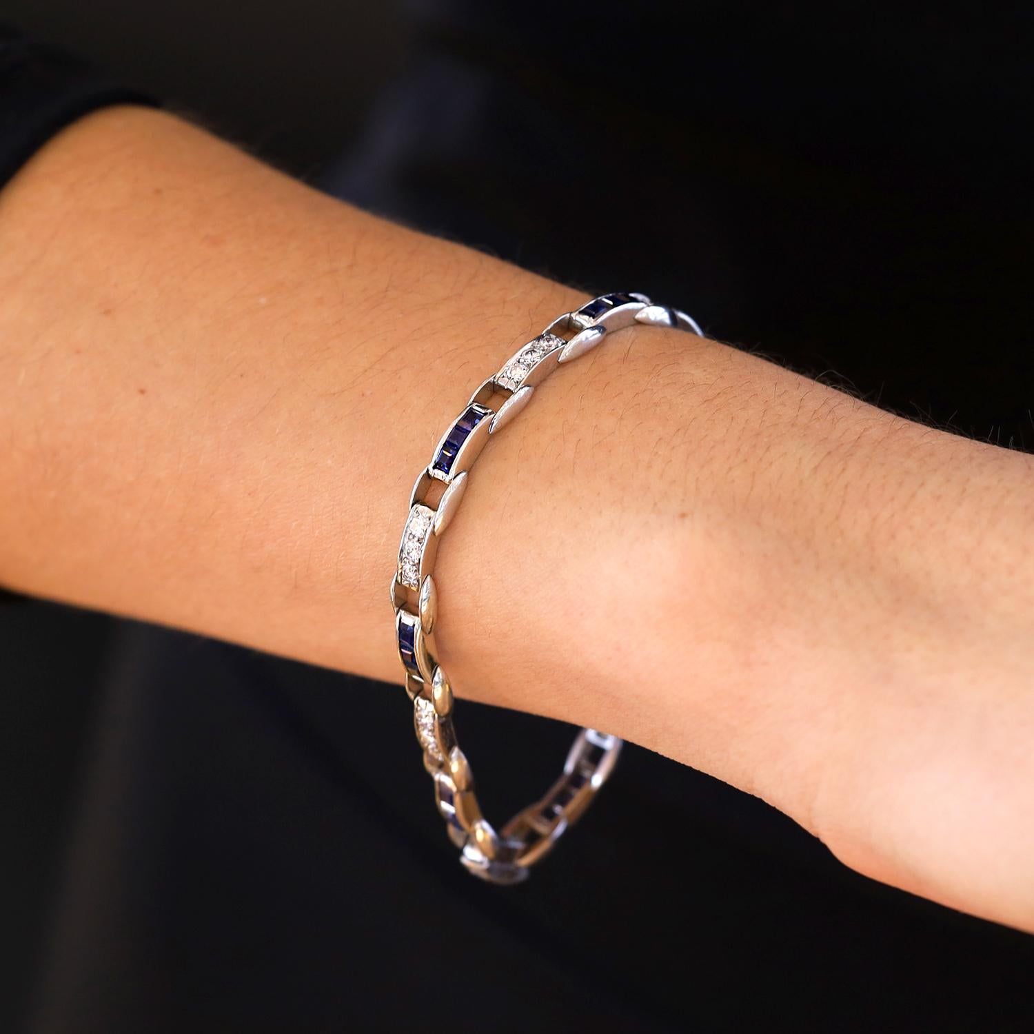 Circle your wrist with the most sleek and elegant Art Deco diamond and sapphire bracelet. Fabricated of enduring platinum links interspersed with vivid blue, French cut sapphires and brilliant round diamonds. Straight line bracelets were popularized