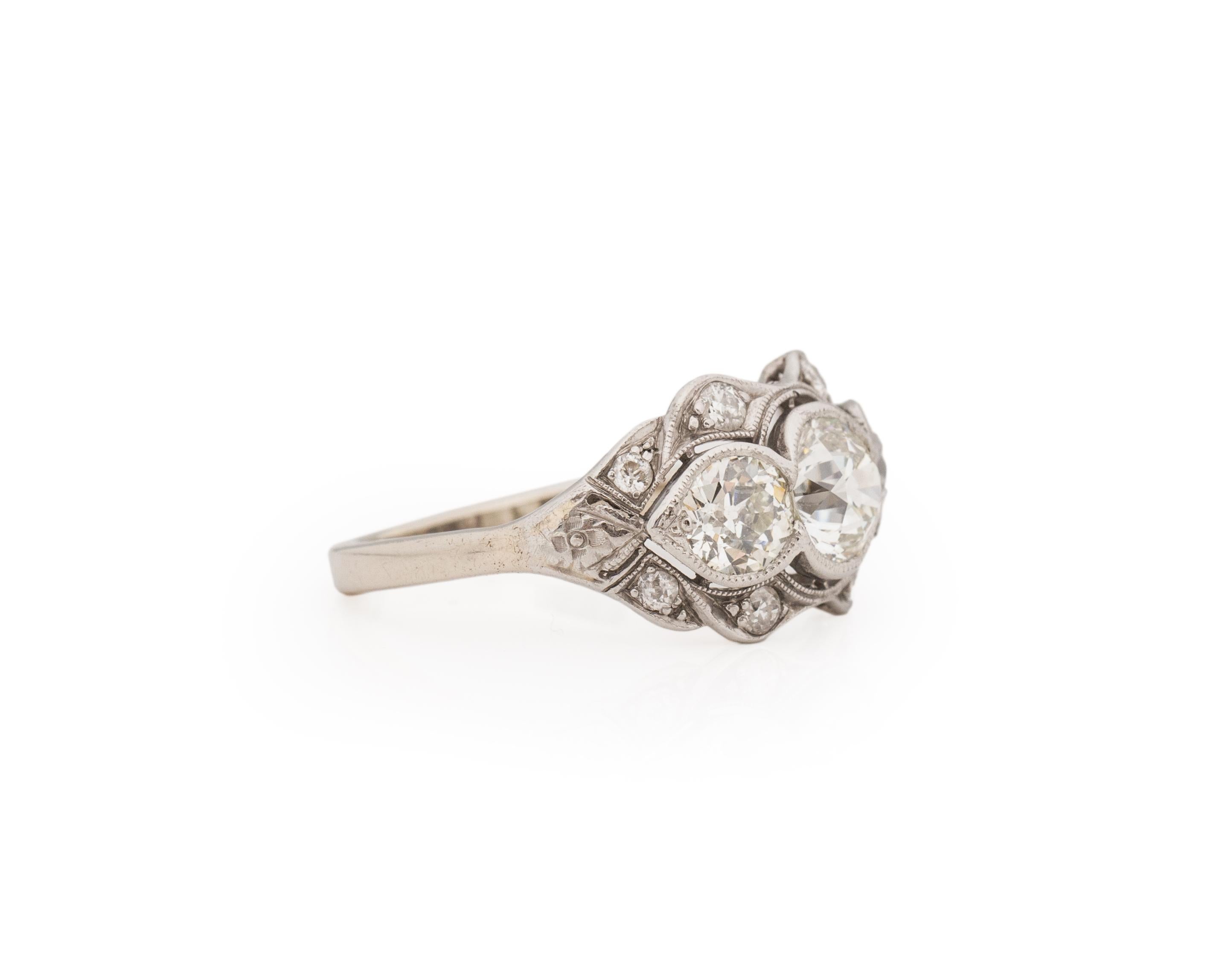 This three stone knockout is a late Edwardian early Art Deco transition piece. The simple style shanks leads up to the 1920's, great Gatsby style three stone setting. Adorning the ring are a handful of single cut diamonds adding a little extra to