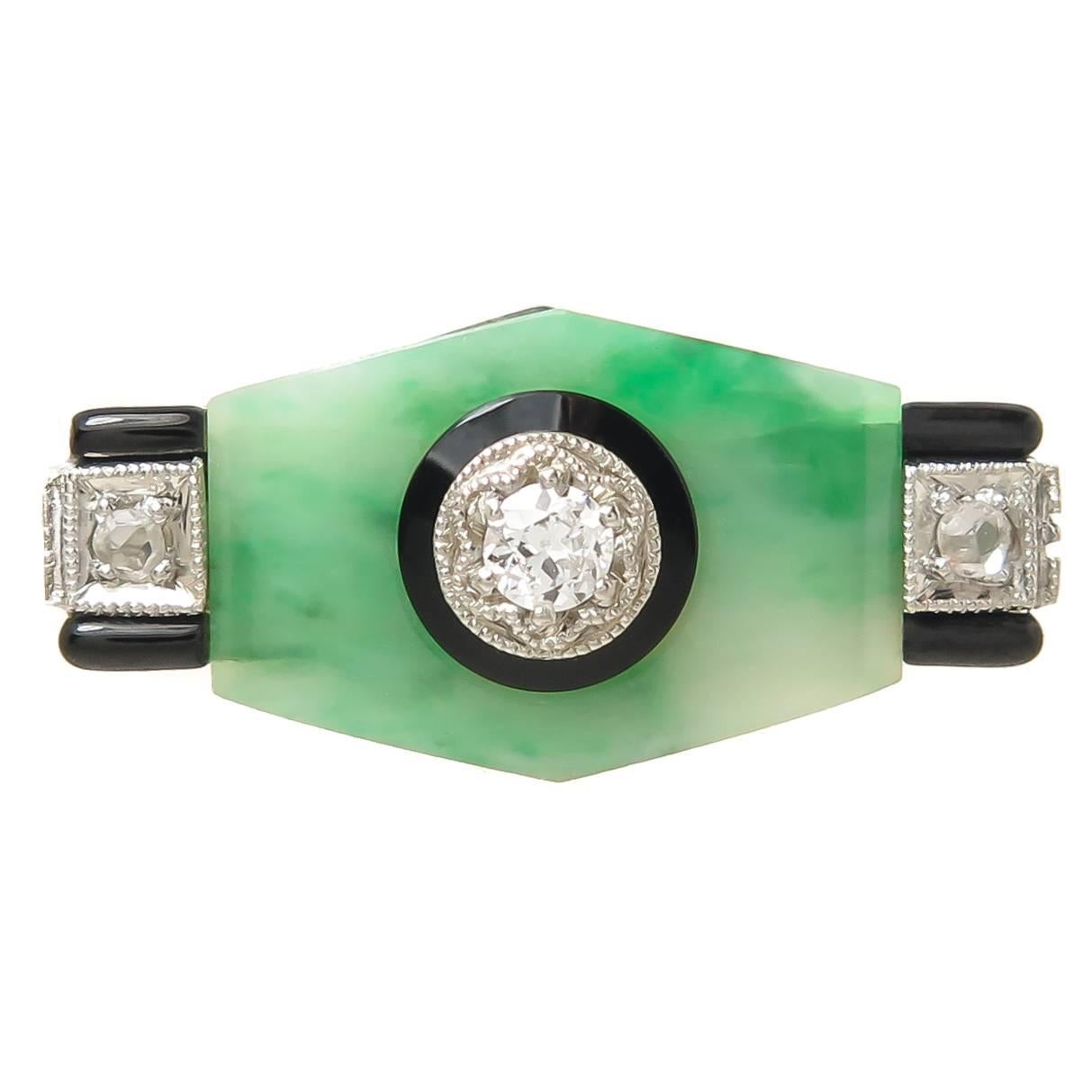 Circa 1930 Art Deco Ring, with a center section of Jade, Black Onyx and further decorated with Black Enamel and set with Old cut Diamonds. The top of the ring measures 3/4 inch in length and 3/8 inch wide. Finger size = 6. Excellent near unworn