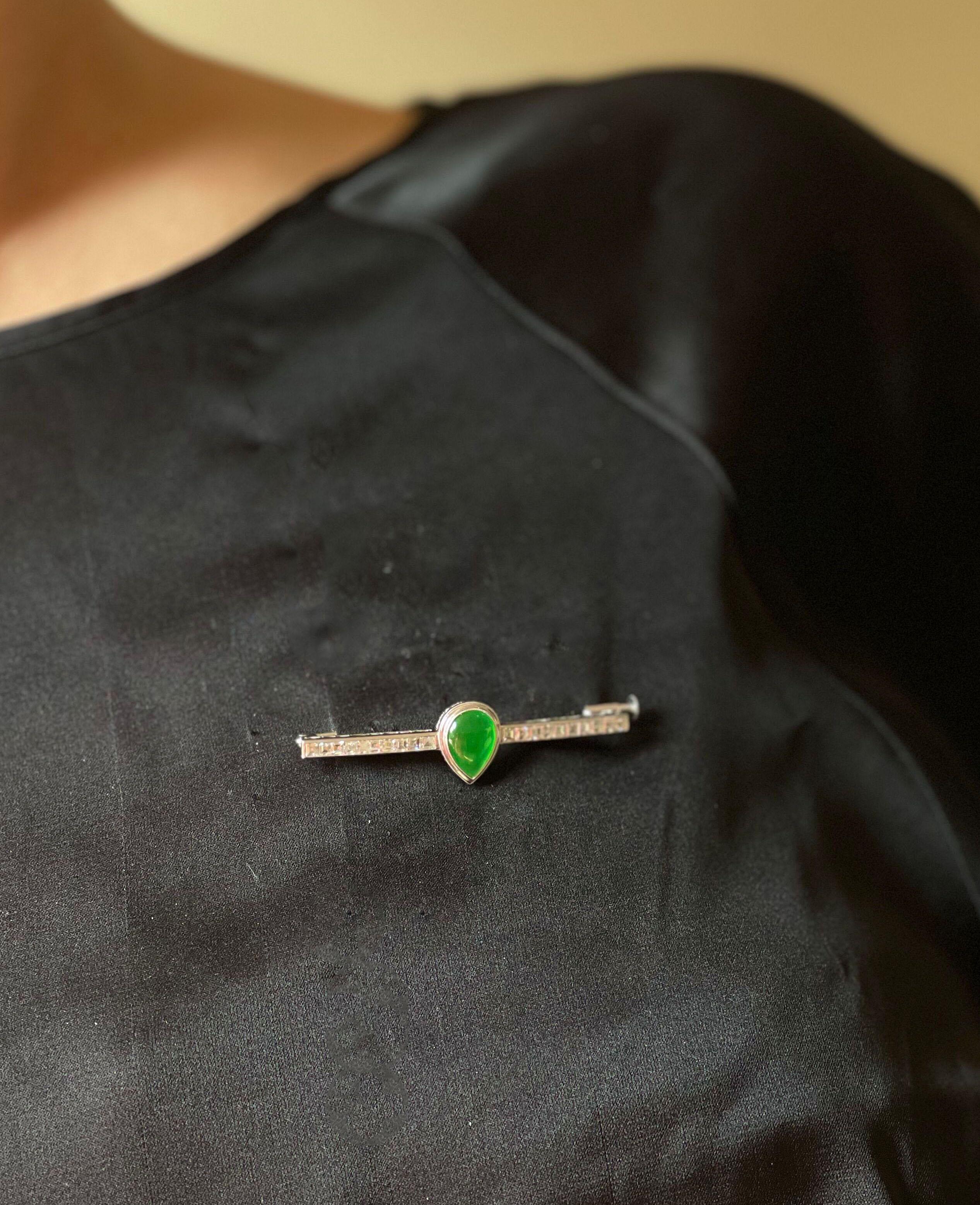 Art Deco platinum bar brooch, with center pear shaped natural jadeite jade cabochon, stone measures 10.8 x 7.85 x 3.7mm. Surrounded with approx. 1.50ctw GH/VS diamonds. Brooch measures 2 1/8