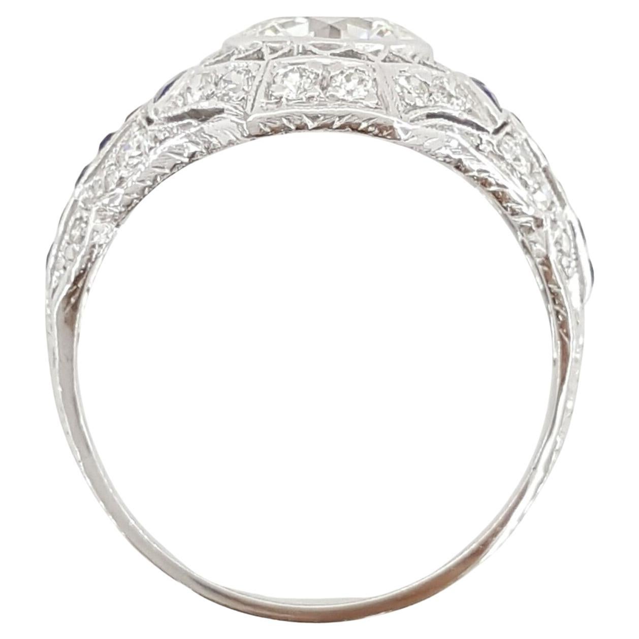 Une bague de fiançailles art déco authentique en platine, avec un diamant rond de taille brillant et un saphir.
