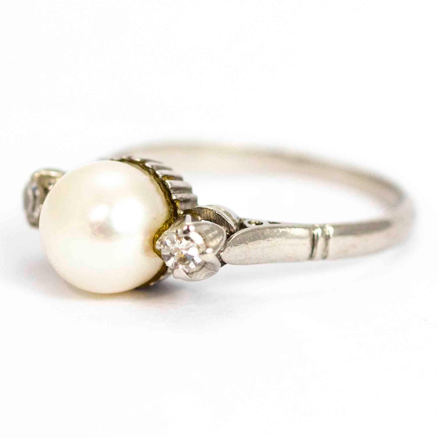 A stunning vintage Art Deco three-stone ring set with pearl and diamonds. The beautiful large central pearl measures 7.35mm in diameter, and is flanked by two wonderful old mine cut diamonds each measuring 10 points. Total diamond weight is 20