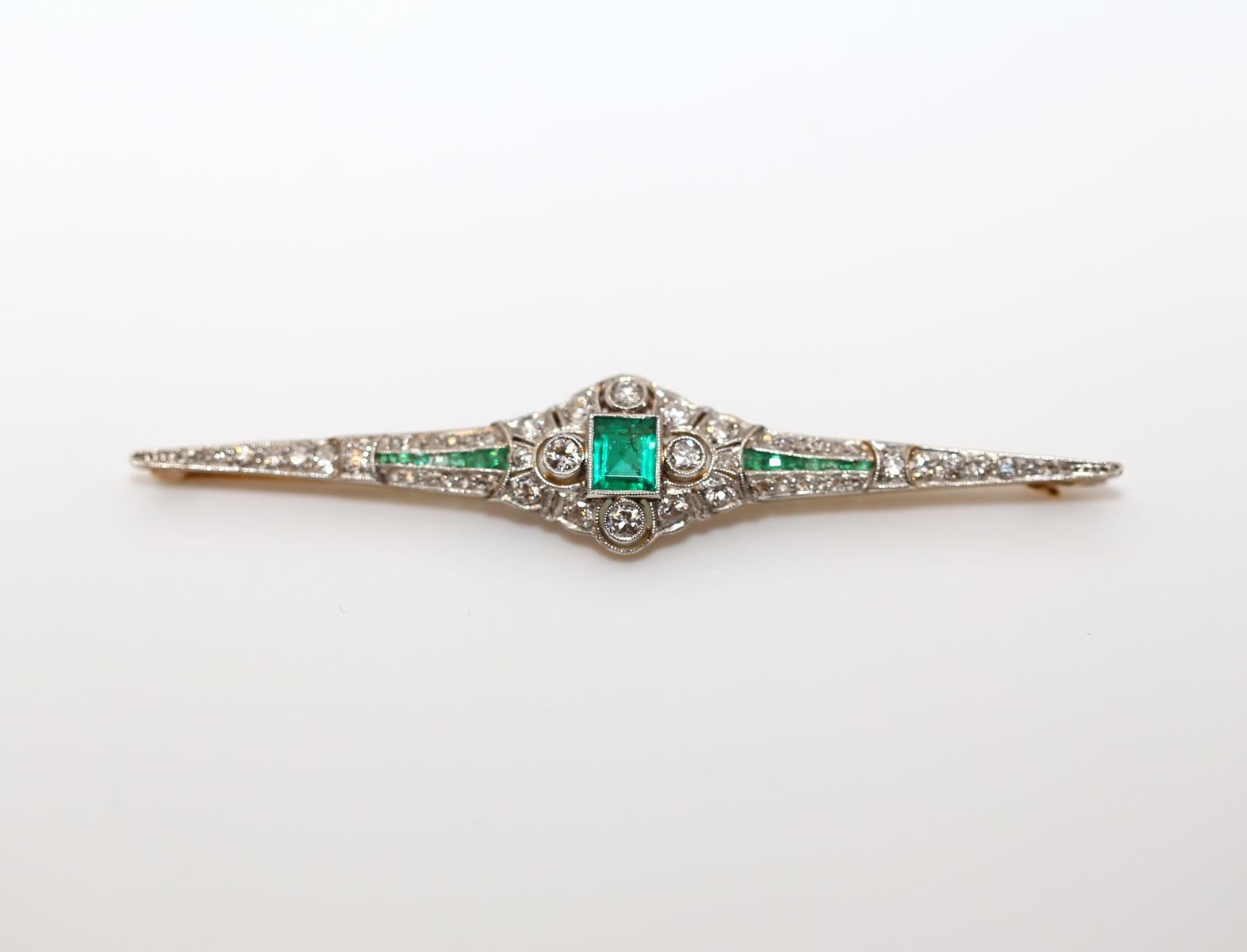 
Art Deco platinum antique emerald and diamond bar brooch. The center stone is a fine princess cut Emerald. Diamonds are old European-cut. Wonderfully executed item an amazing example of it’s era yet a stylish accessory that can be worn today. The