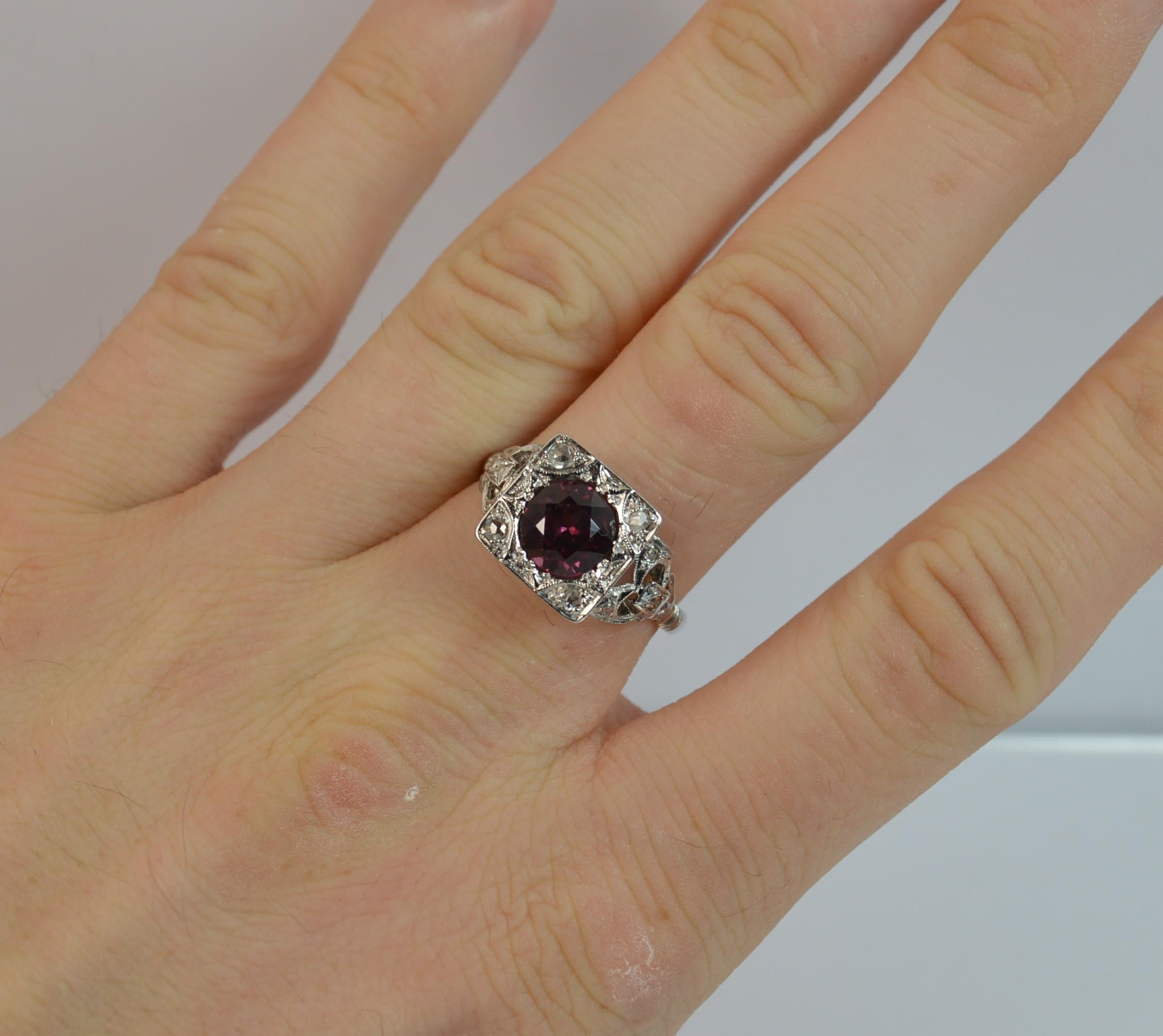 A stunning ladies Platinum, Garnet and Diamond ring.

​A true art deco period piece, circa 1920/30's.

​Designed with a large rhodolite garnet to the centre with four rose cut diamonds to the head. Fine pierced and engraved head. A further four rose