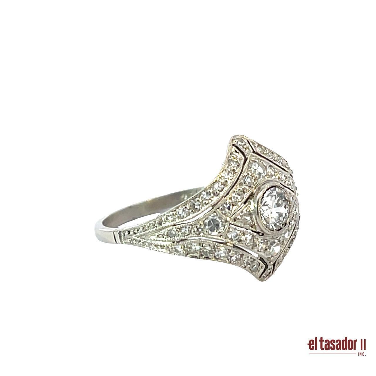 Questo raffinato anello Art Deco in platino (4,2 grammi) presenta un diamante centrale con taglio a brillante del peso di 0,38 carati, incastonato in un sorprendente disegno geometrico. Intorno al centro ci sono altri 0,40 carati di diamanti tondi
