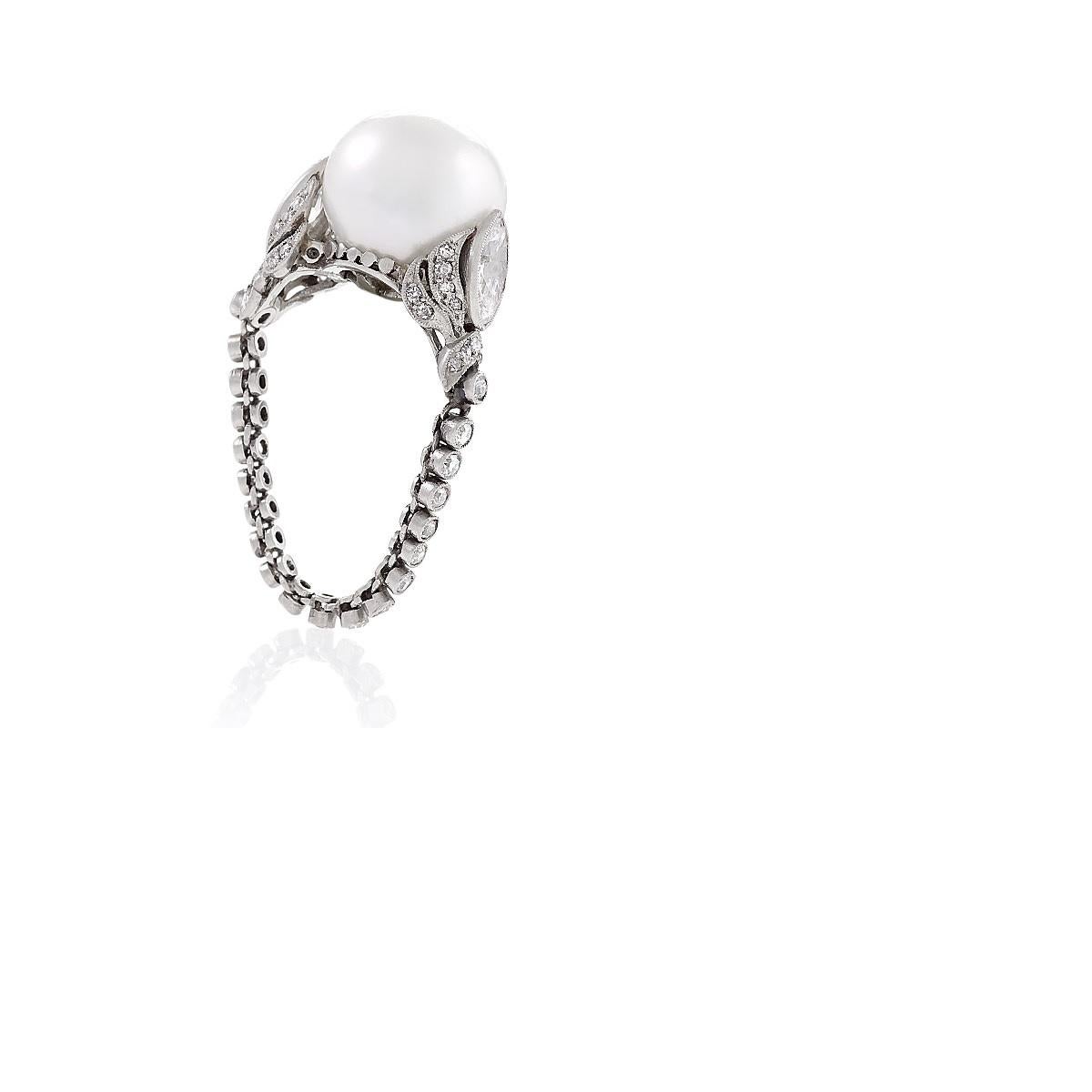 An Art Deco platinum ring with a baroque pearl and diamonds. The ring has 56 round diamonds with an approximate total weight of 0.60 carats and 2 marquise-cut diamonds with an approximate total weight of 1.00 carats. The baroque pearl mounted in the