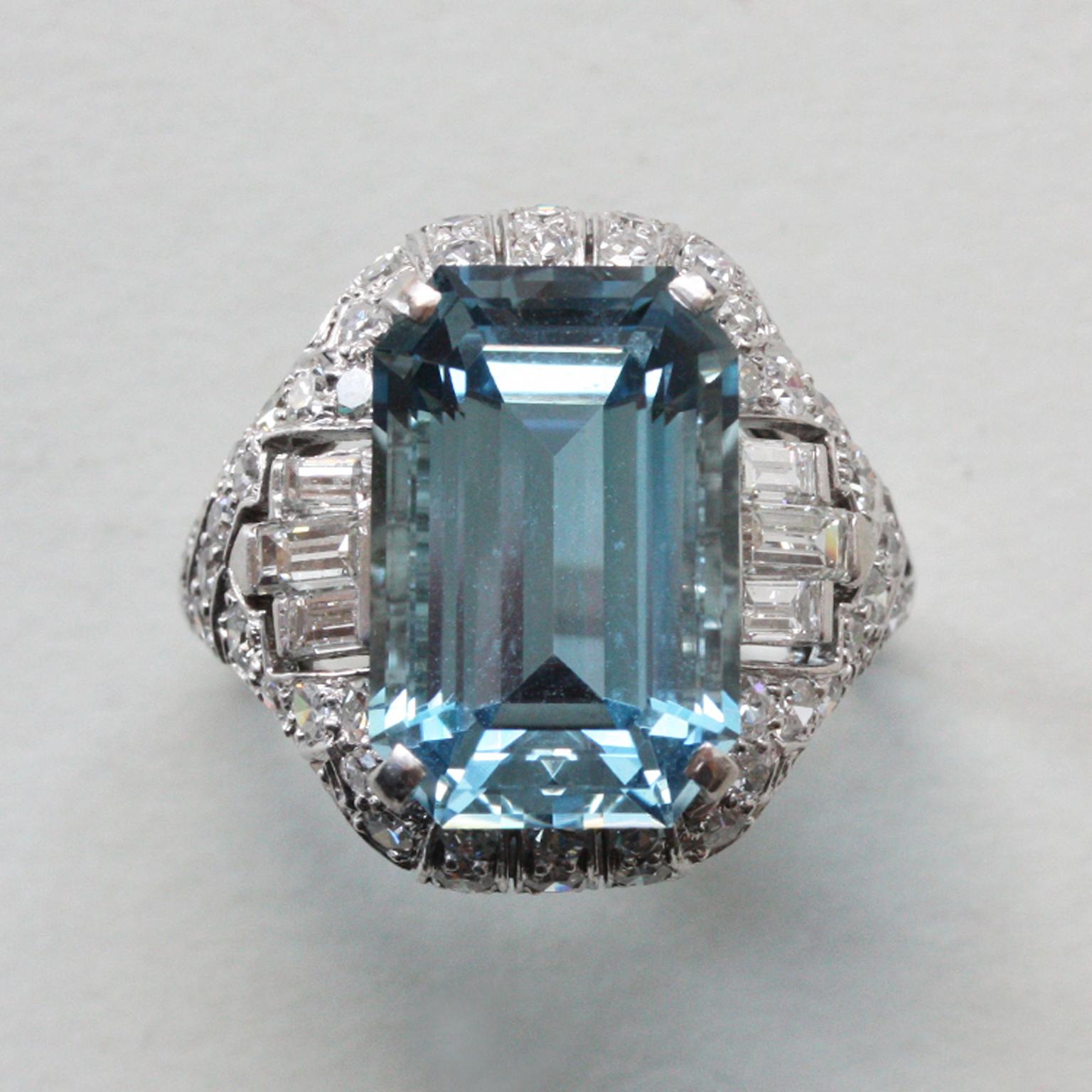 A spectacular platinum Art Deco ring with an emerald cut aquamarine (app. 8.5 carats) surrounded by old cut diamonds and on the side are three baguette cut diamonds in different sizes, the shank is set with 21 diamonds brilliantcut diamonds (app.