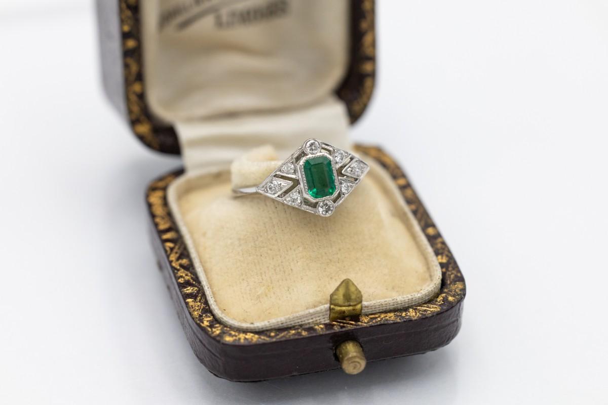 A unique Art Deco style ring made of platinum. The ring is set with a central faceted emerald with an intense green color and a mass of approx. 0.55 ct.

Additionally, the ring is decorated with 8 diamonds with a total mass of approx. 0.20 ct (color